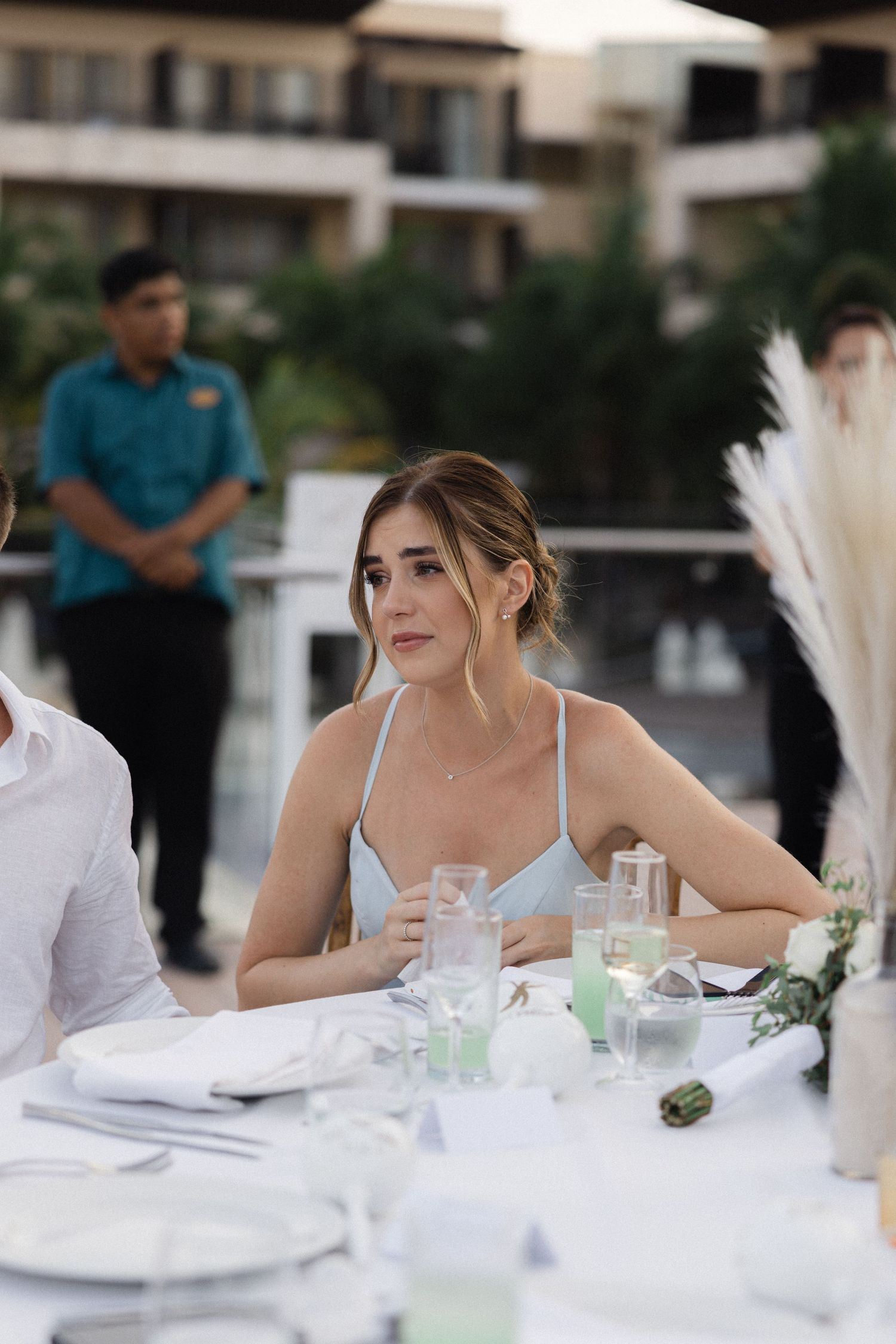 Wedding reception guest sitting at an elegantly decorated outdoor table.