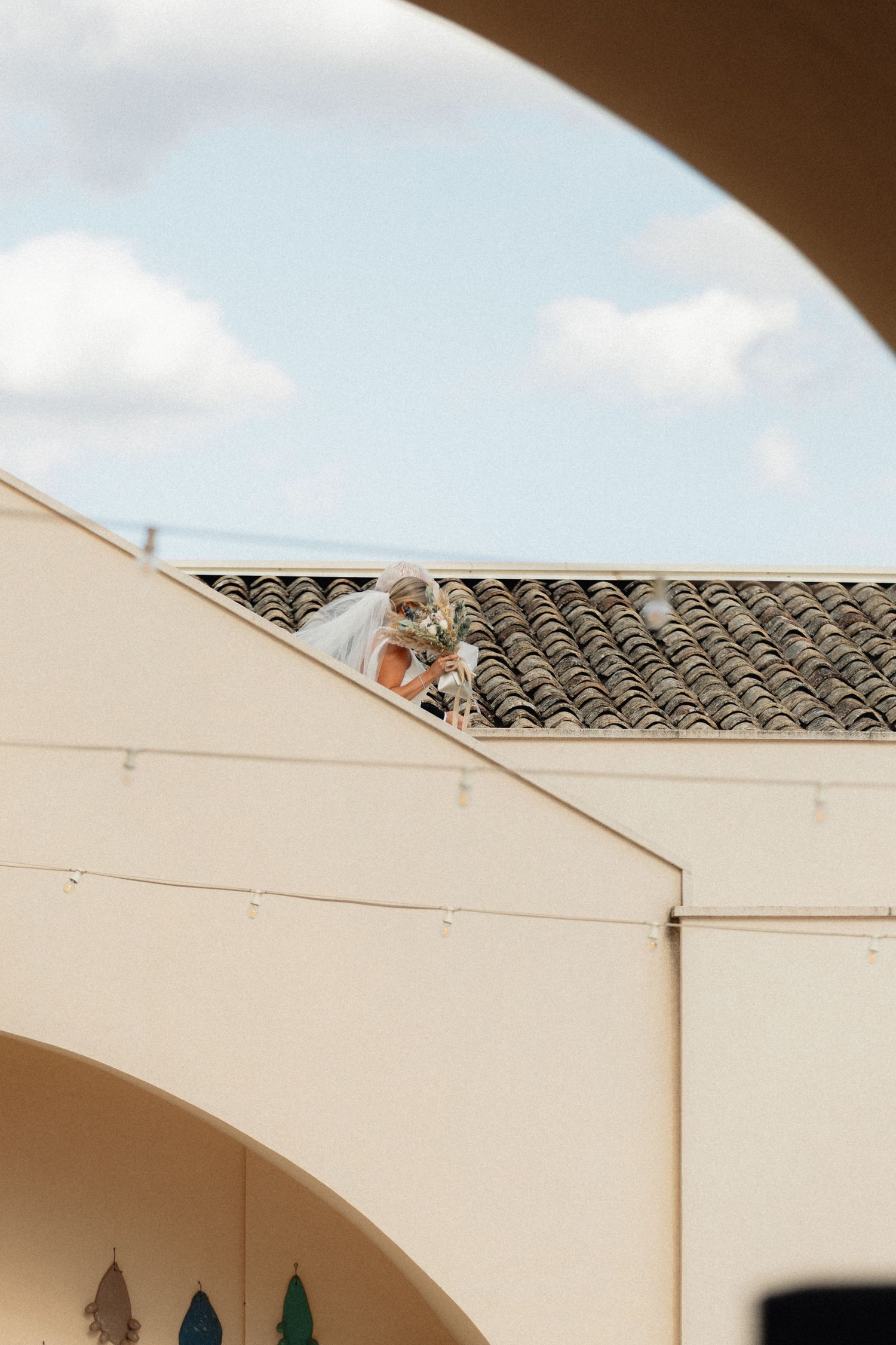 White architectural details and tile roofing against a bright blue sky create geometric shapes.