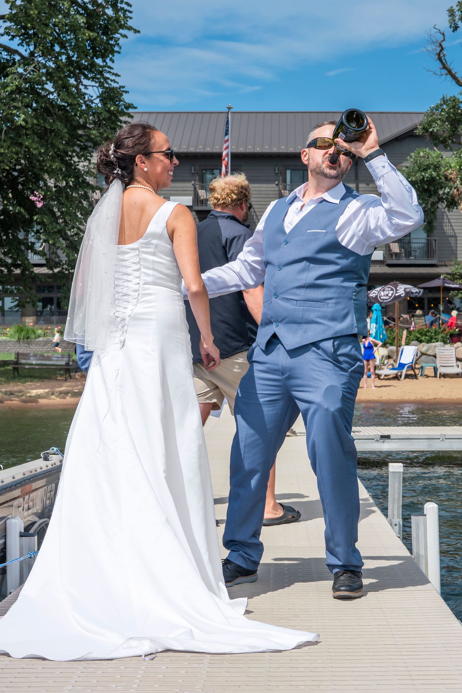 Wedding couple posing on a wooden dock by the waterfront on their special day.