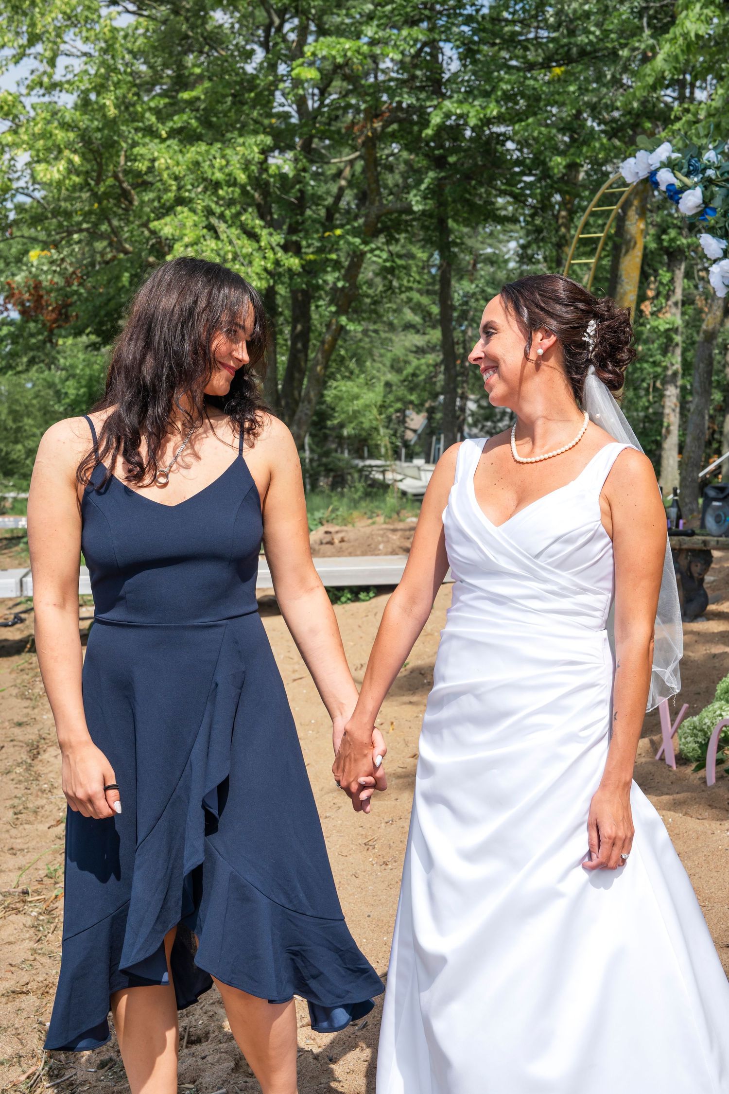 Mom and daughter share a joyful dance moment in a wooded outdoor setting.