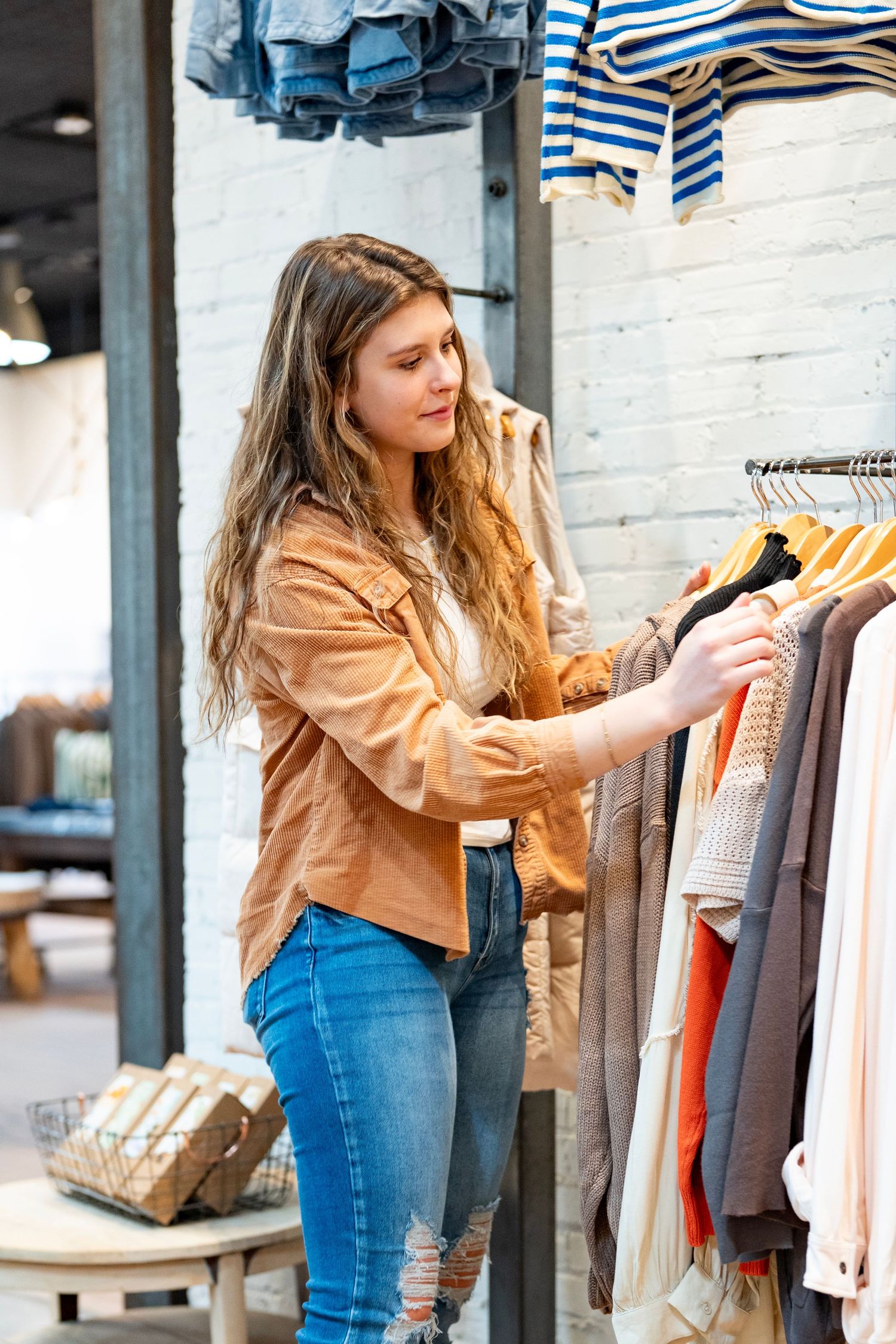 Person browsing through clothing racks in a boutique in downtown Bemidji.