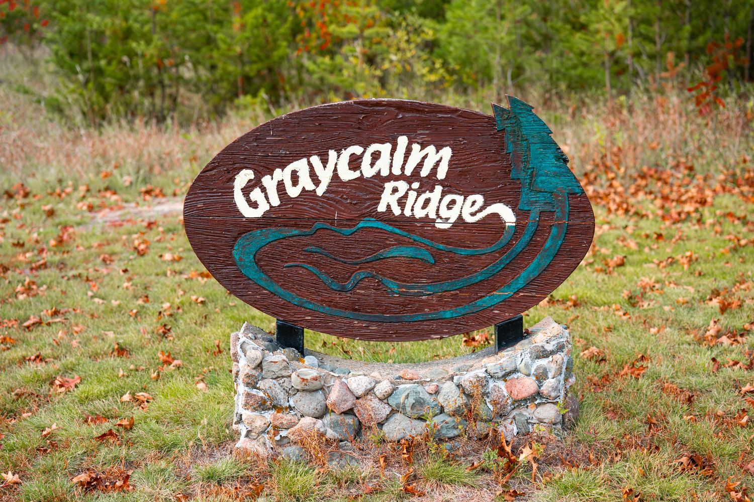 Decorative stone signs with names carved into them displayed in a natural outdoor setting.