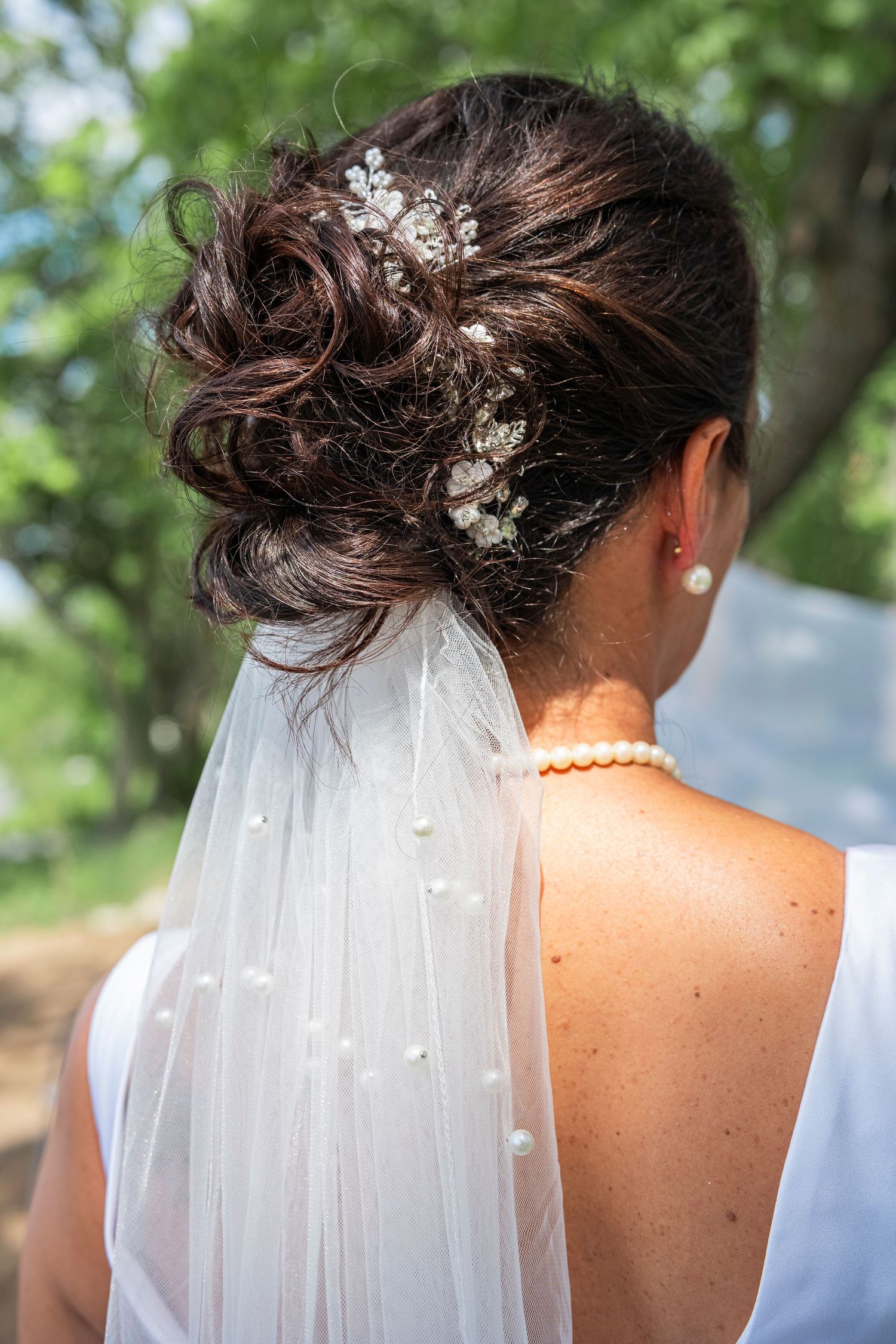 Close-up of bridal hairstyle with floral accessories and veil.