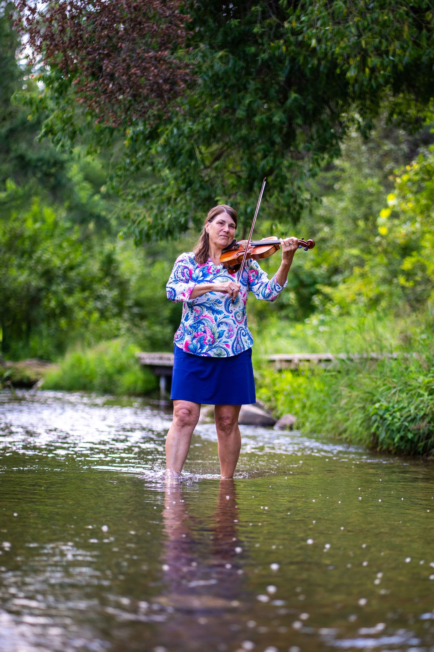Violinist performing in the water at the Mississippi Headwaters.