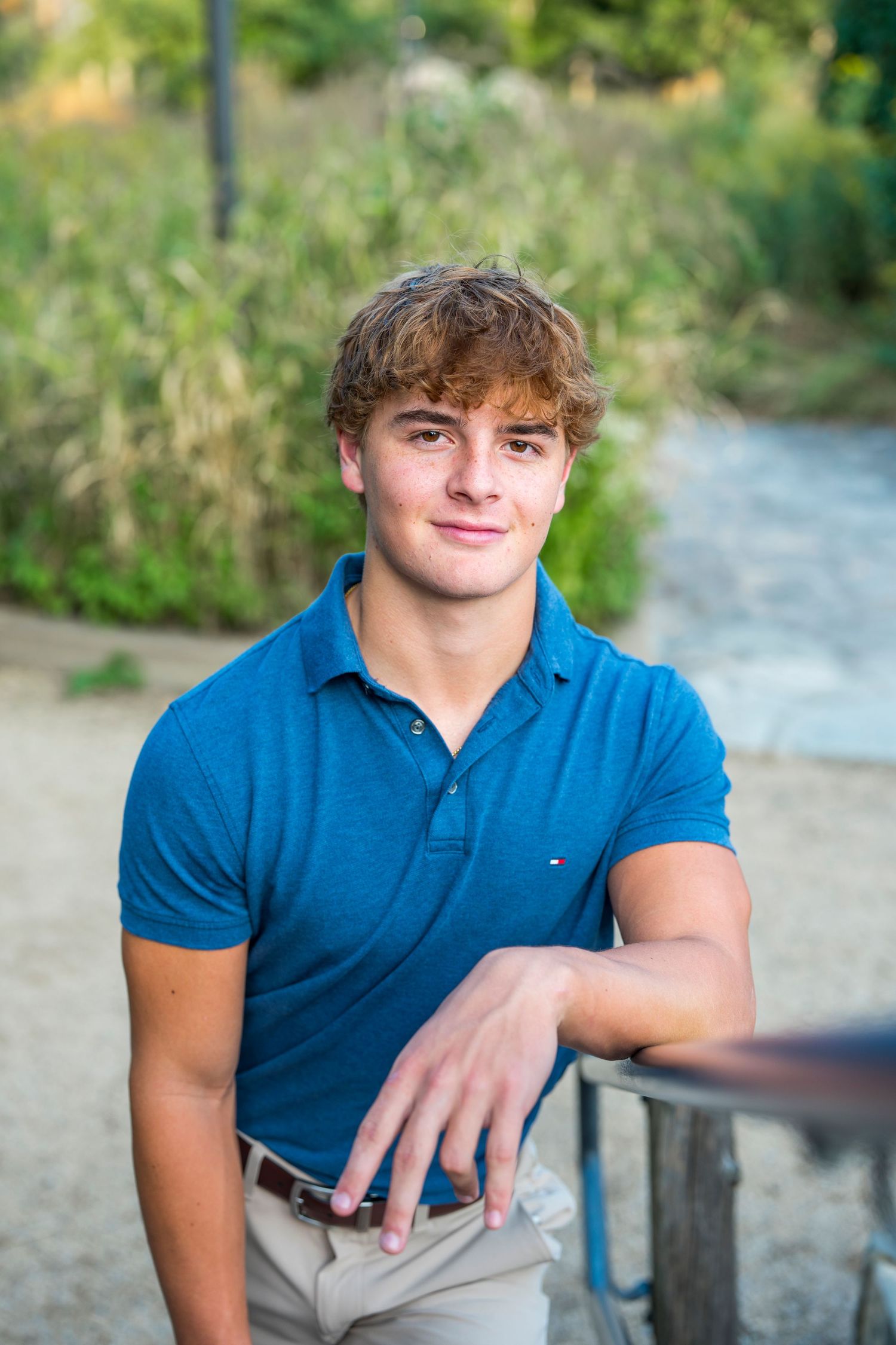 Relaxed outdoor photoshoot featuring casual blue polo and natural scenery.