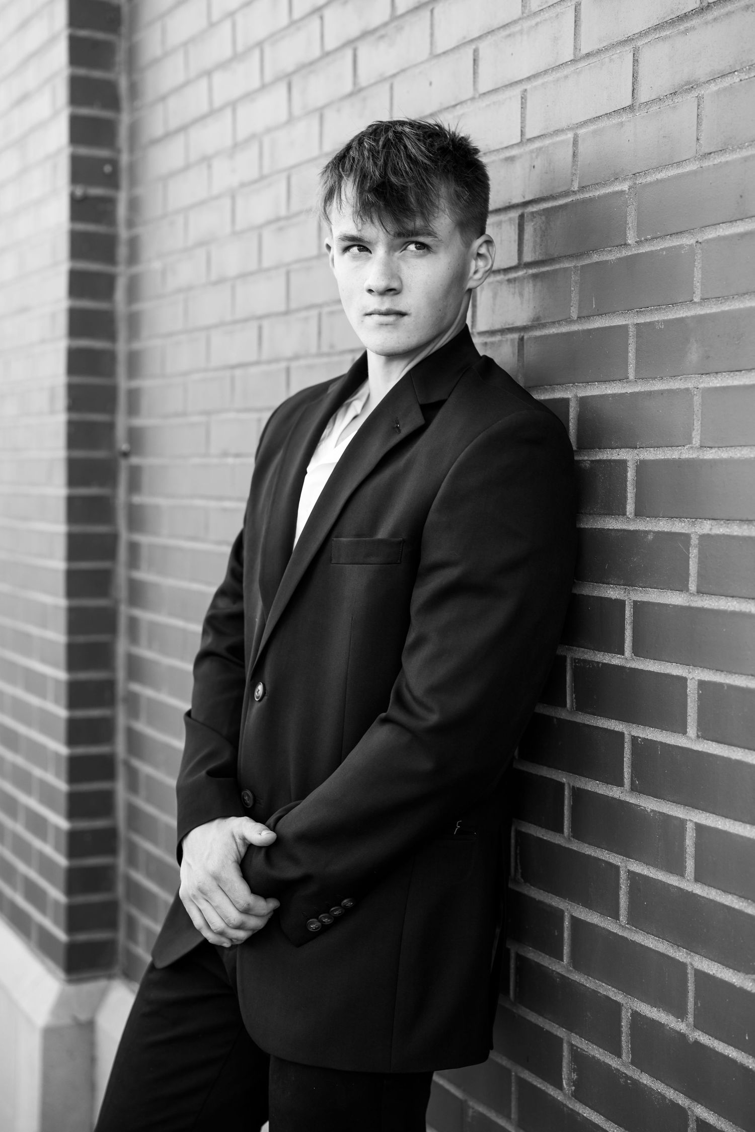 Black and white portraits showing different angles against an industrial brick backdrop.