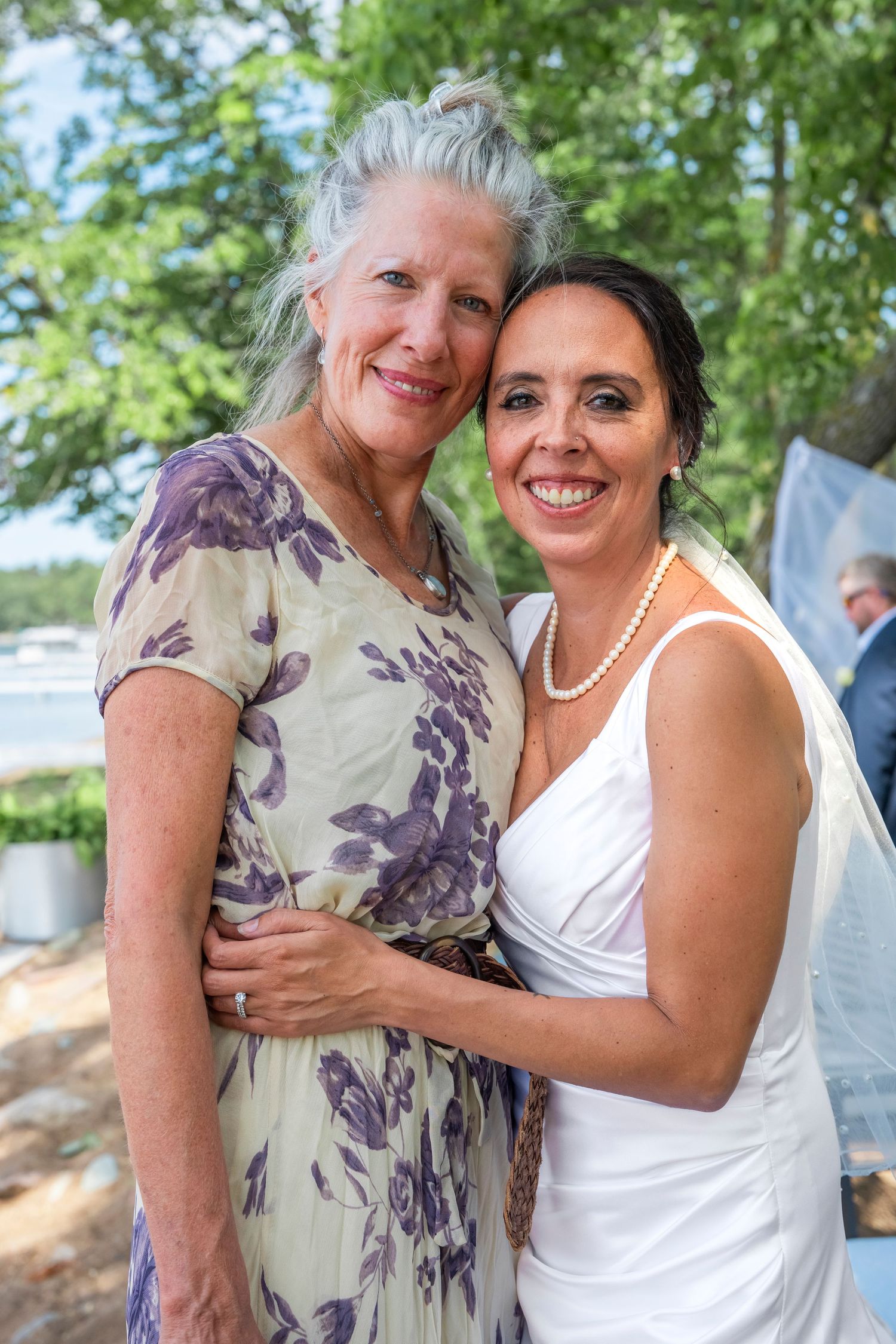 Wedding celebration moment with two people embracing outdoors on a sunny day.