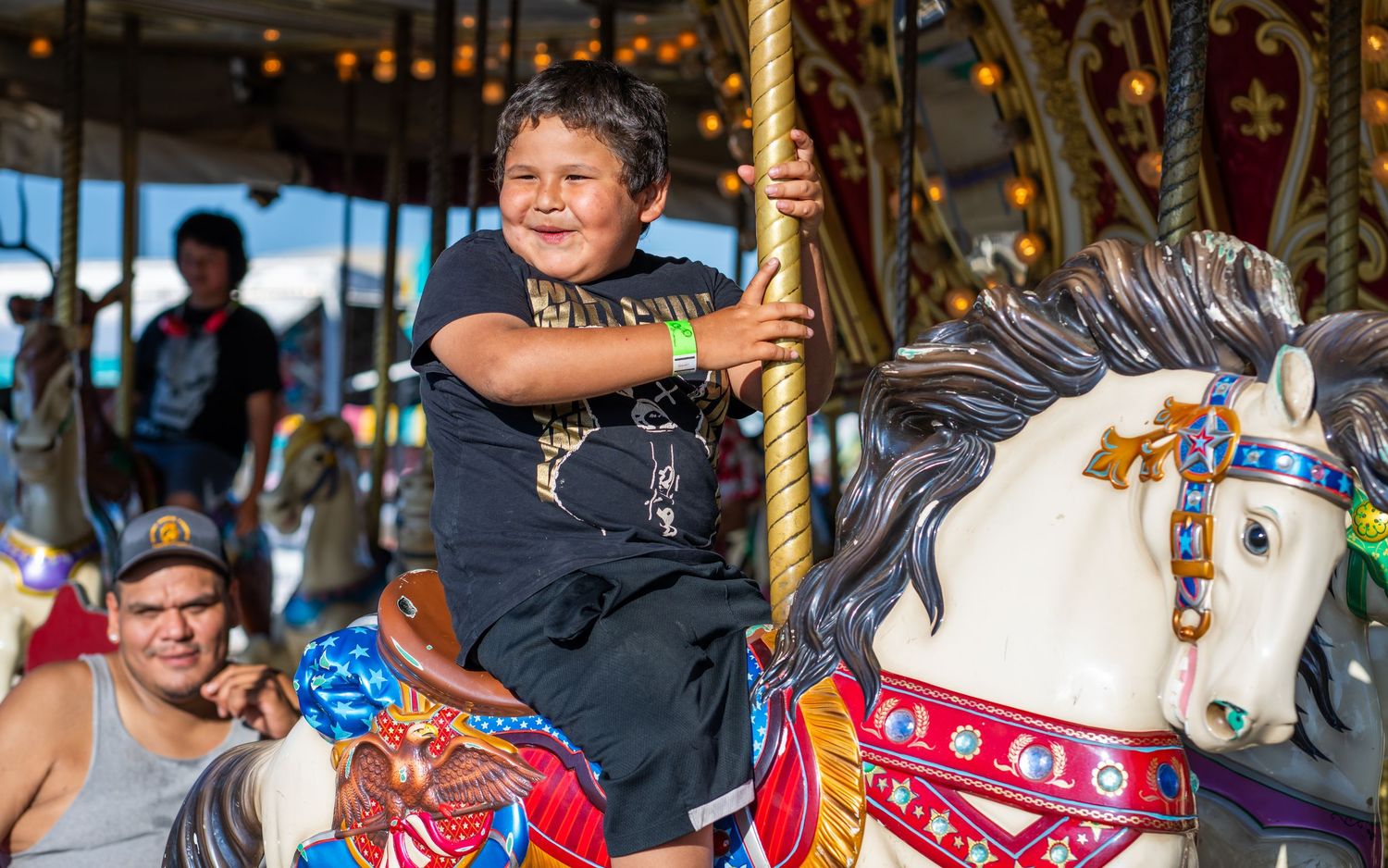 Carousel horse with ornate decorations spins on Merry Go Round..