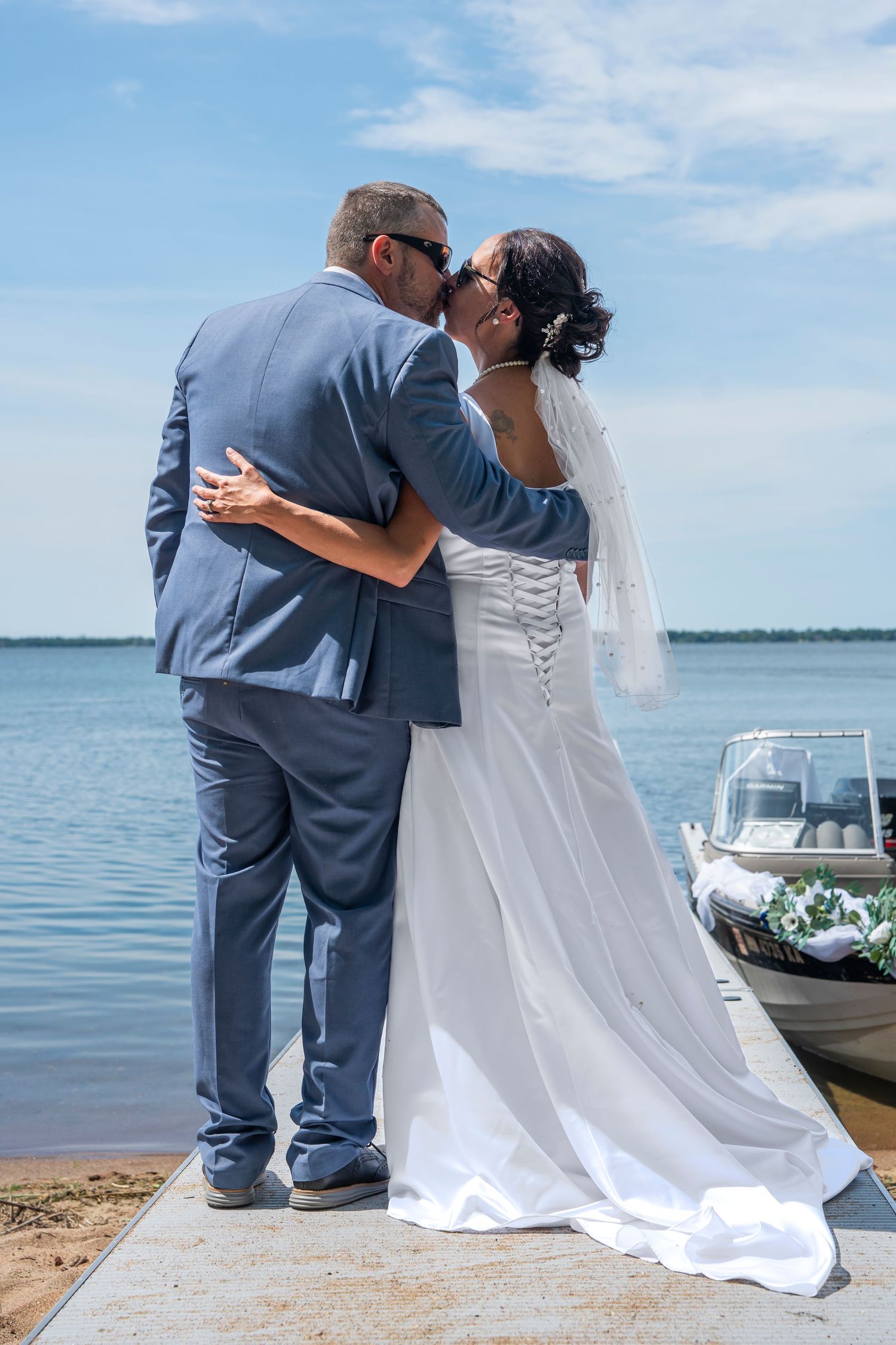 Romantic wedding photo session by the waterfront with boats in background.