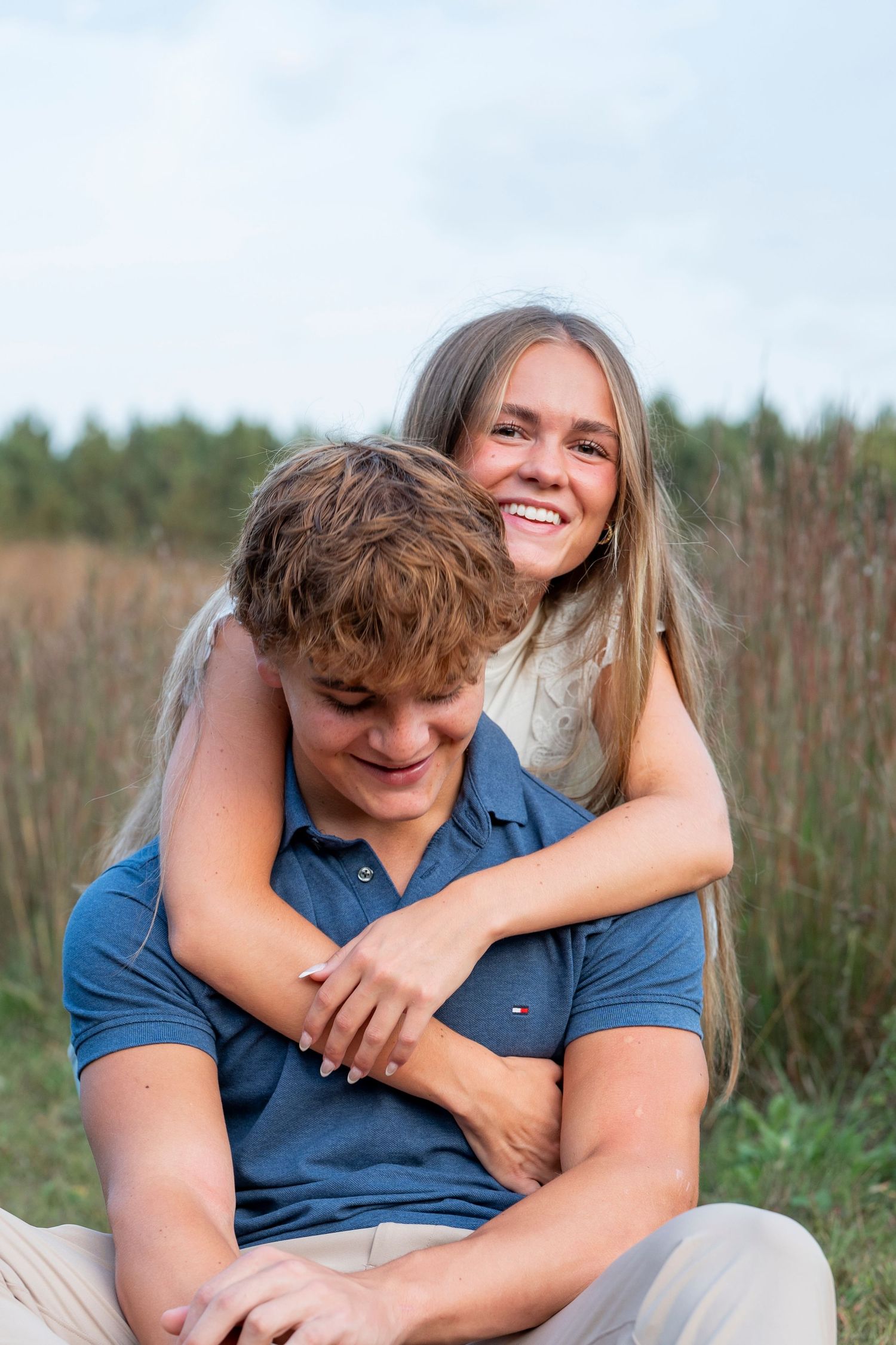 Couple sharing intimate moments while relaxing in a grassy meadow.