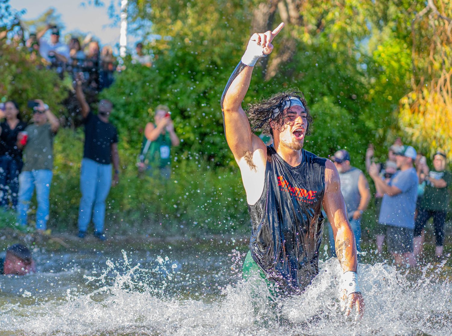 Crowd of people splashing and playing in water after football game.