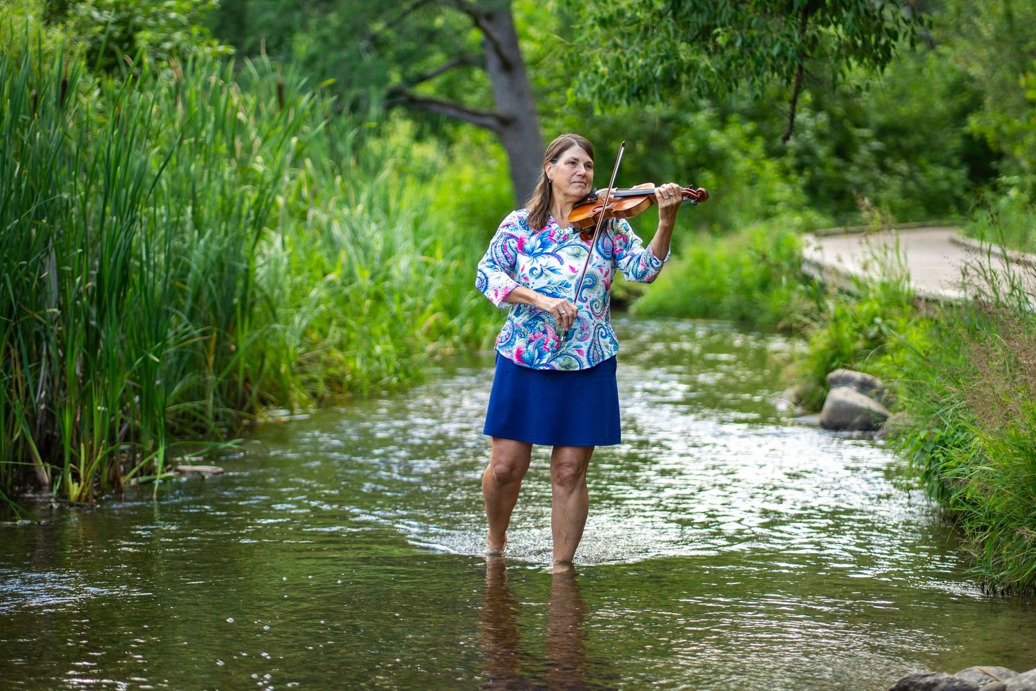 Violinist performing in the water at the Mississippi Headwaters.
