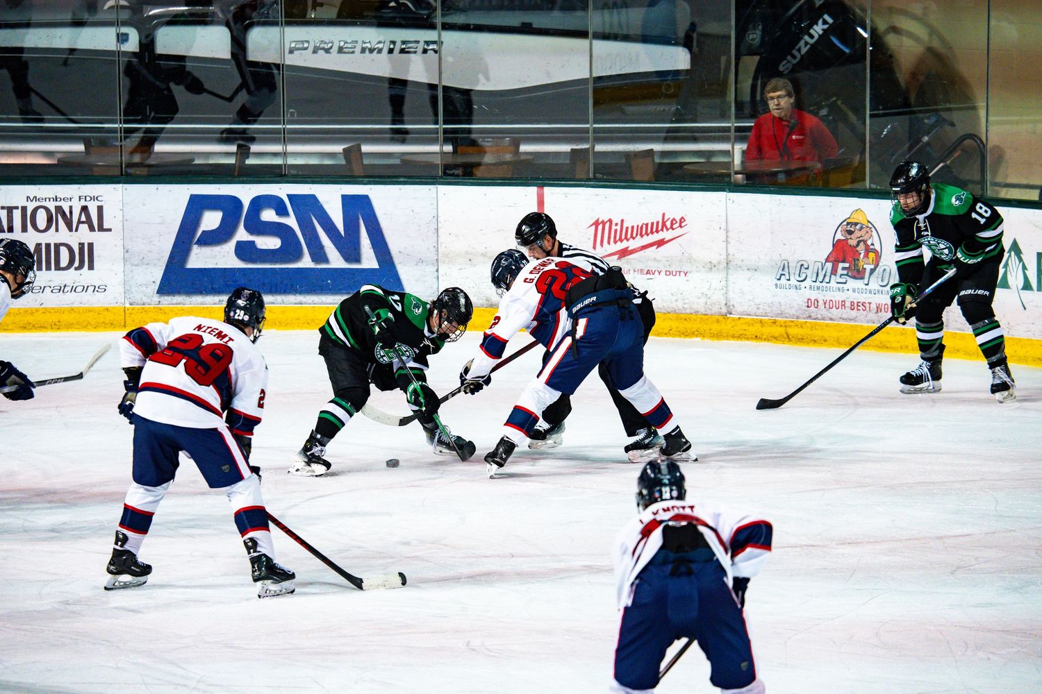 Ice hockey players competing in a fast-paced game with clear view of the rink.