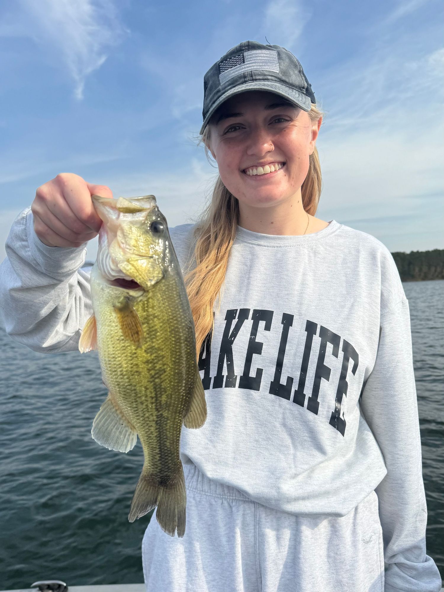A series of fishing photos showing caught bass being displayed on a boat during a sunny day on the lake.