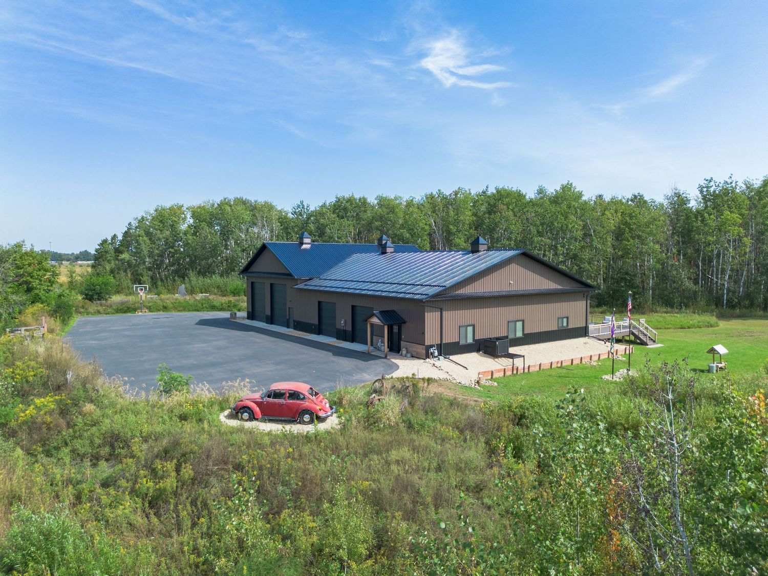 Scenic landscape view of buildings and structures spread across rolling green hills under blue skies.