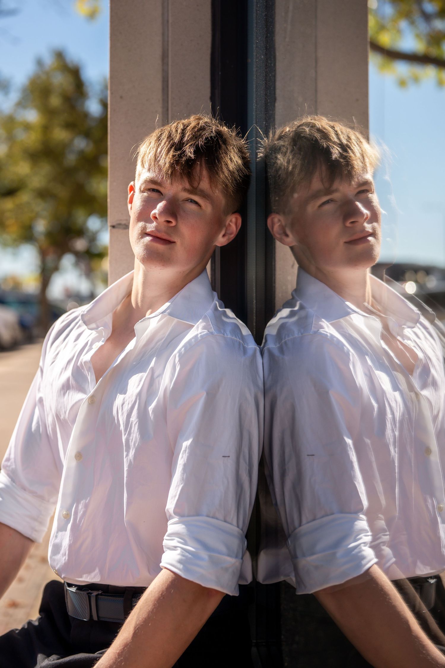 Artistic portrait series with reflective surfaces showing multiple angles in formal attire.