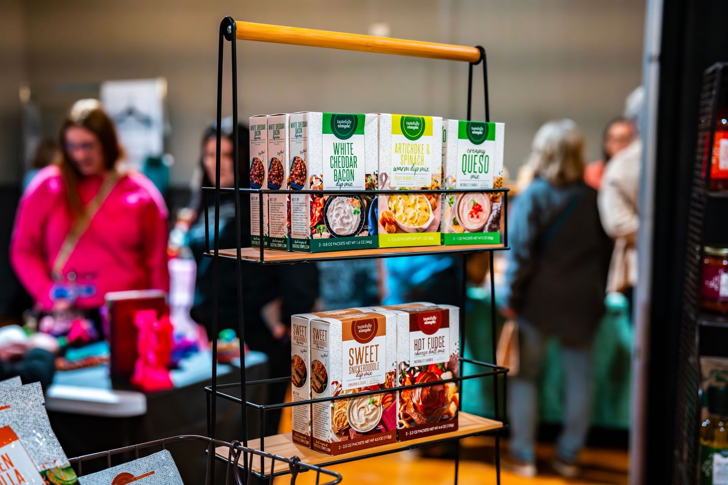 Vendor at marketplace with packaged products under ambient lighting.