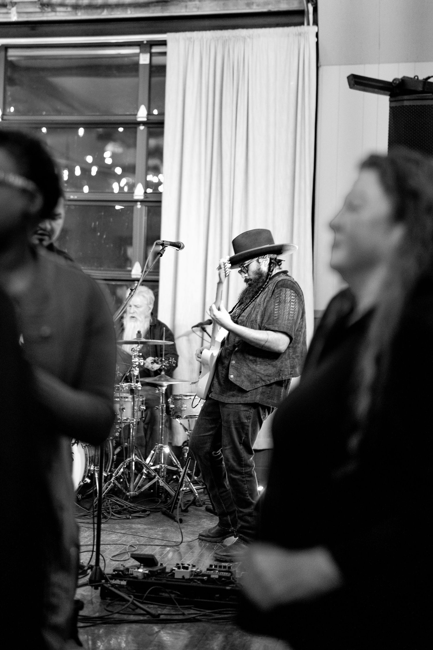 Live band performs on stage with lead singer in spotlight during New Years event.