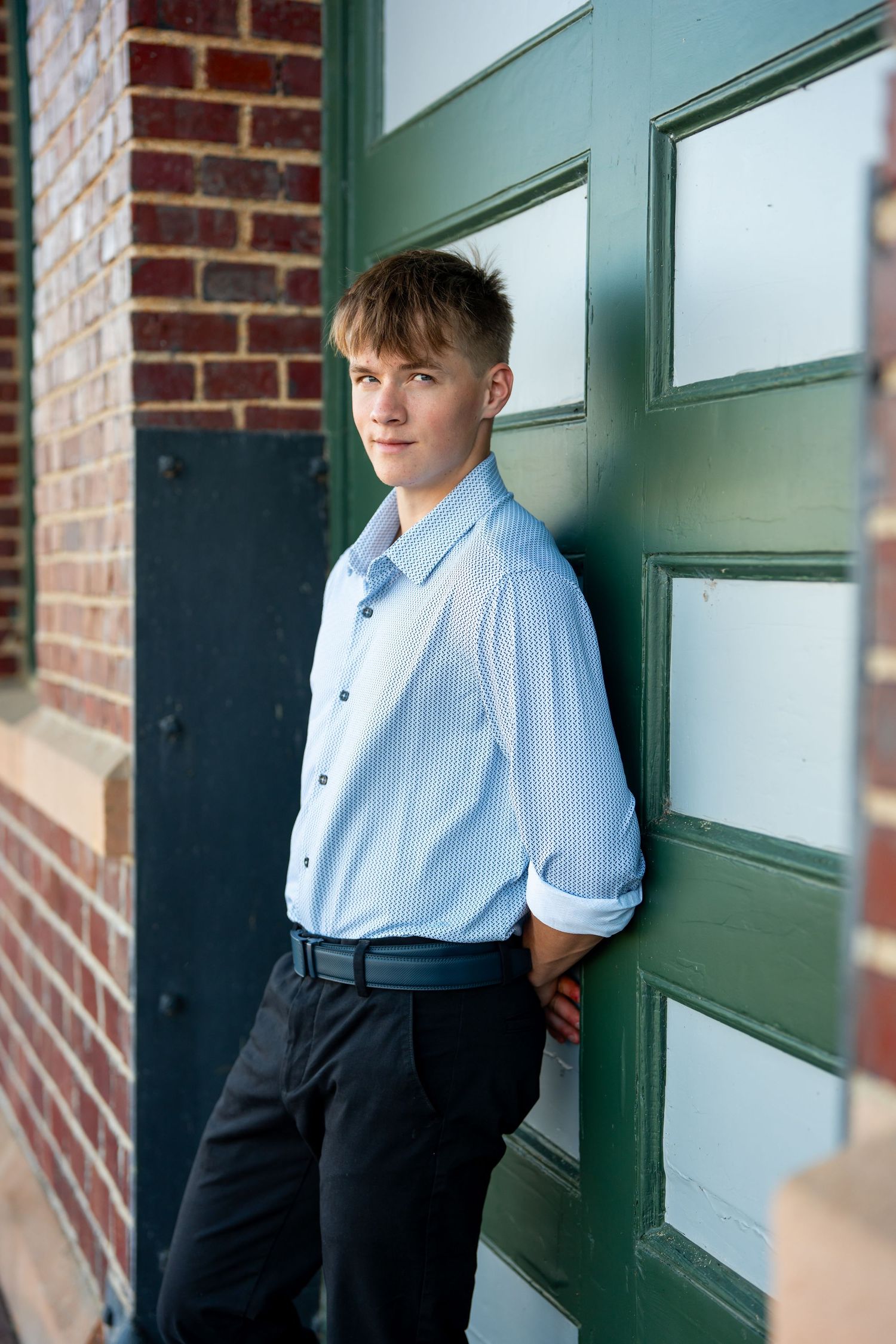 Multiple angles of a casual portrait session against a green door and brick background.