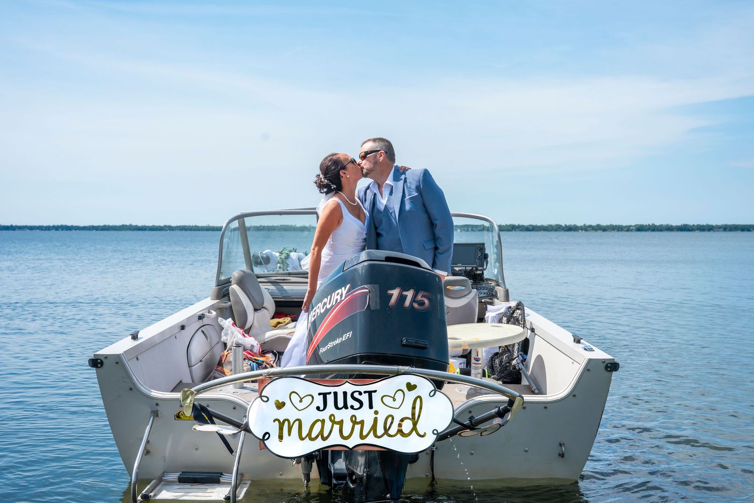 Wedding boat decorated with 'Just Married' sign and floral arrangements on the water.