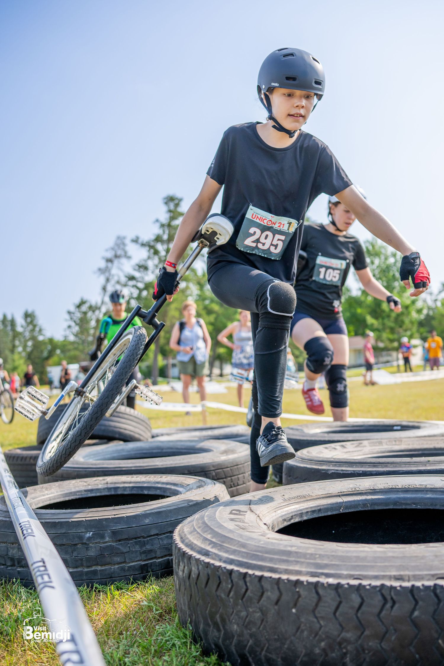 Cyclists maneuvering through a challenging tire obstacle course during a competition.
