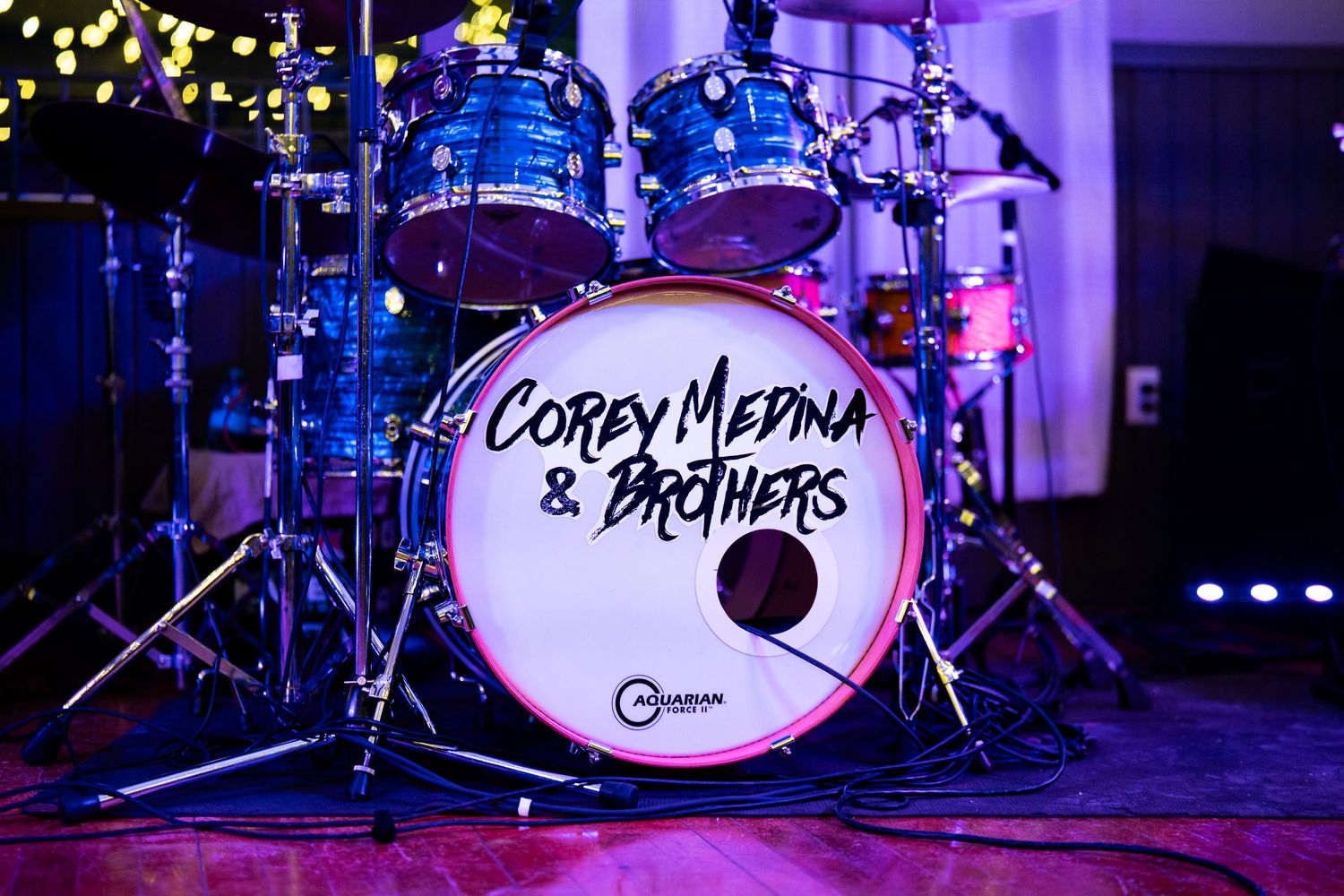 Blue drum kit with 'Corey Medina & Brothers' logo on the bass drum head.