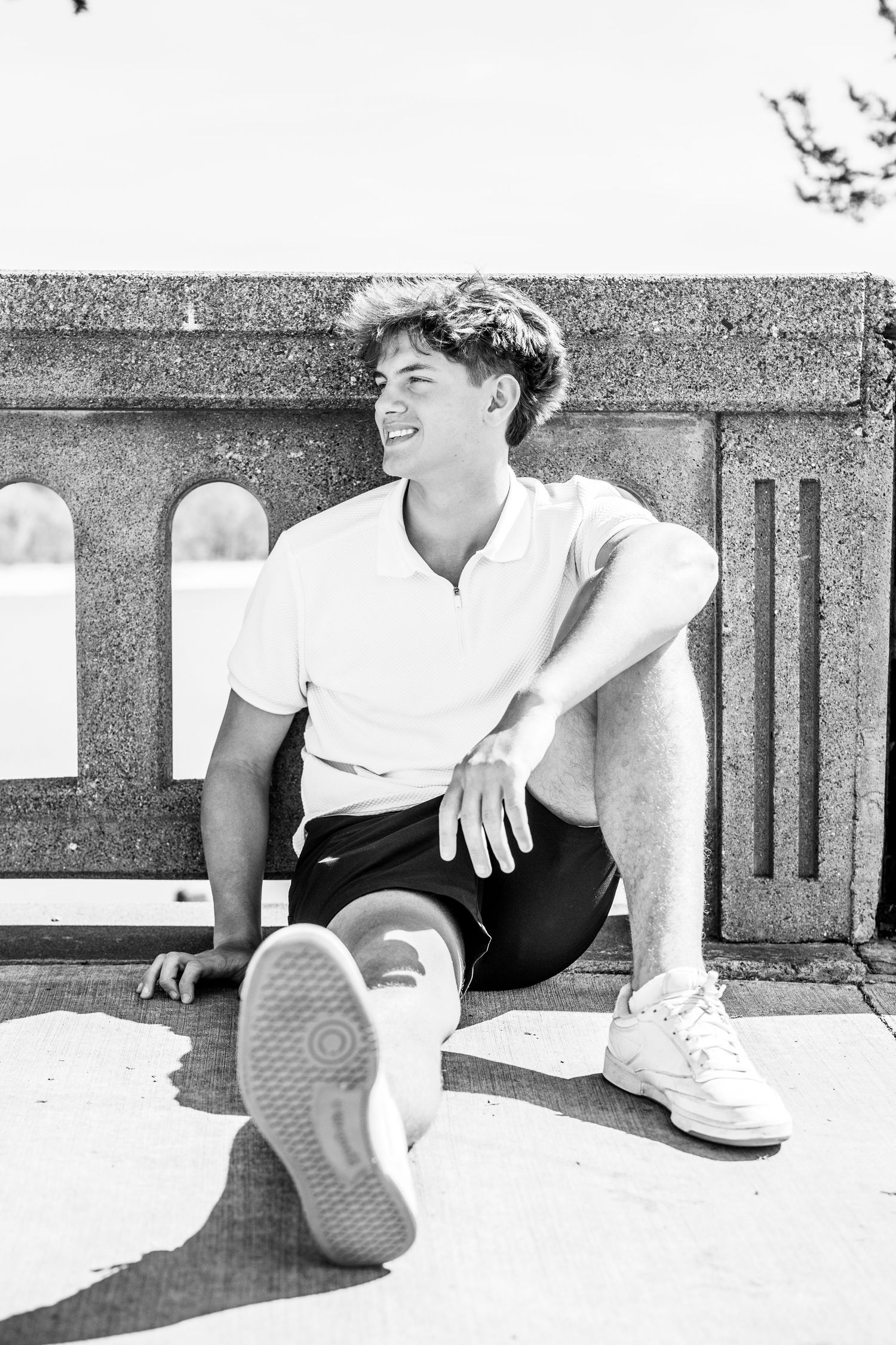 Black and white photo of people sitting and relaxing on concrete steps in casual summer attire.
