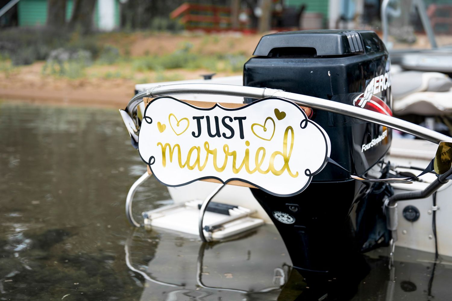 Just Married decorative sign on back of boat at waterfront wedding.