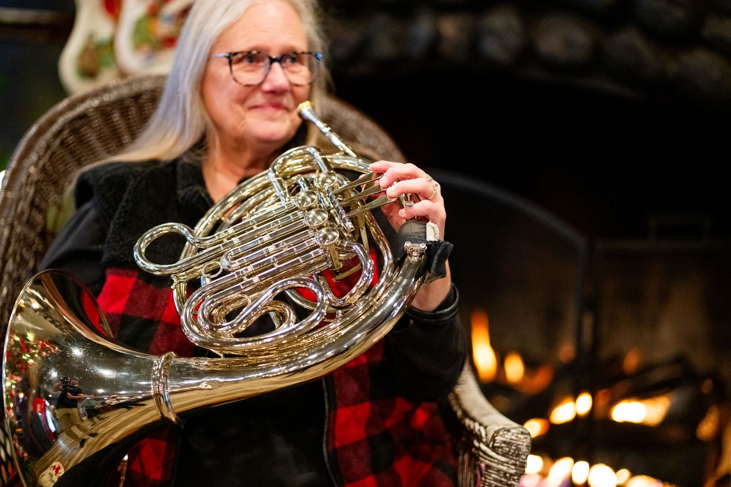 French horn musician performing in a dimly lit venue.