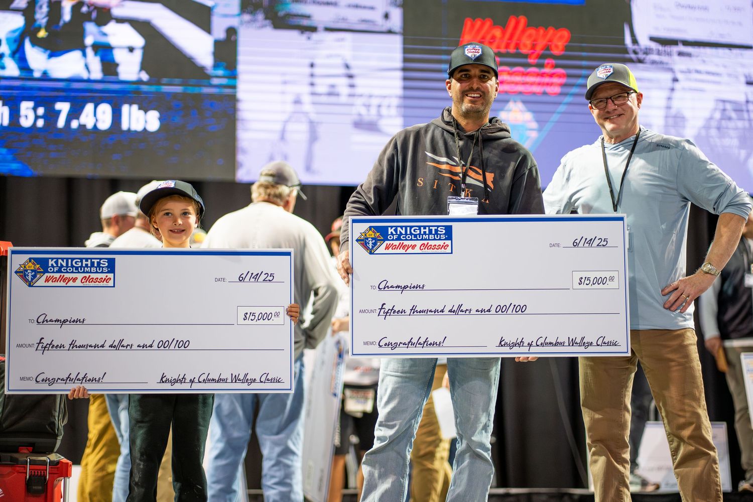 Row of oversized prize checks being displayed at an awards ceremony.
