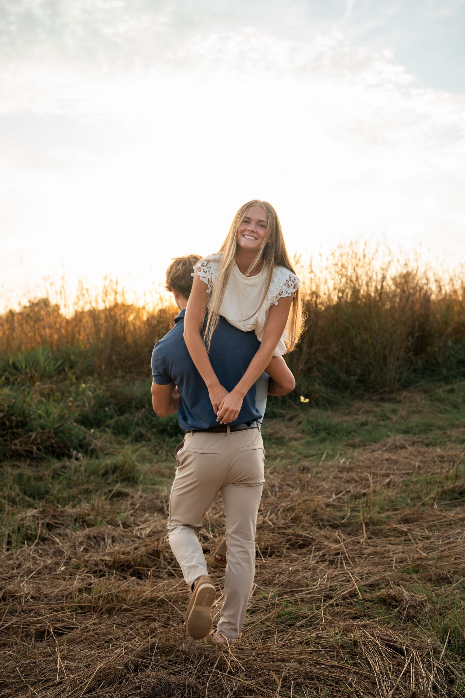 A couple photographed against a sunset sky.