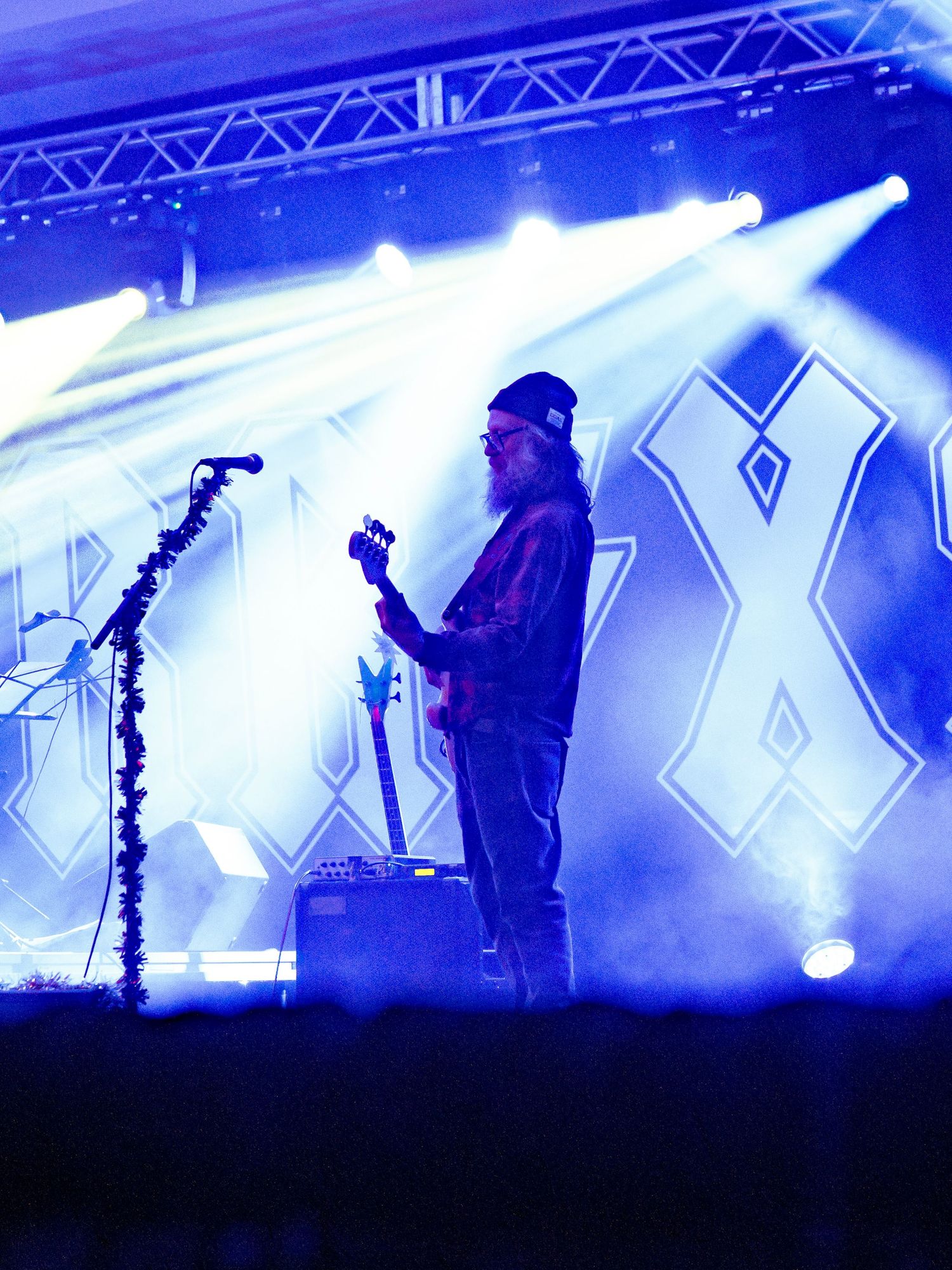 Concert stage with dramatic blue lighting and silhouetted performers.