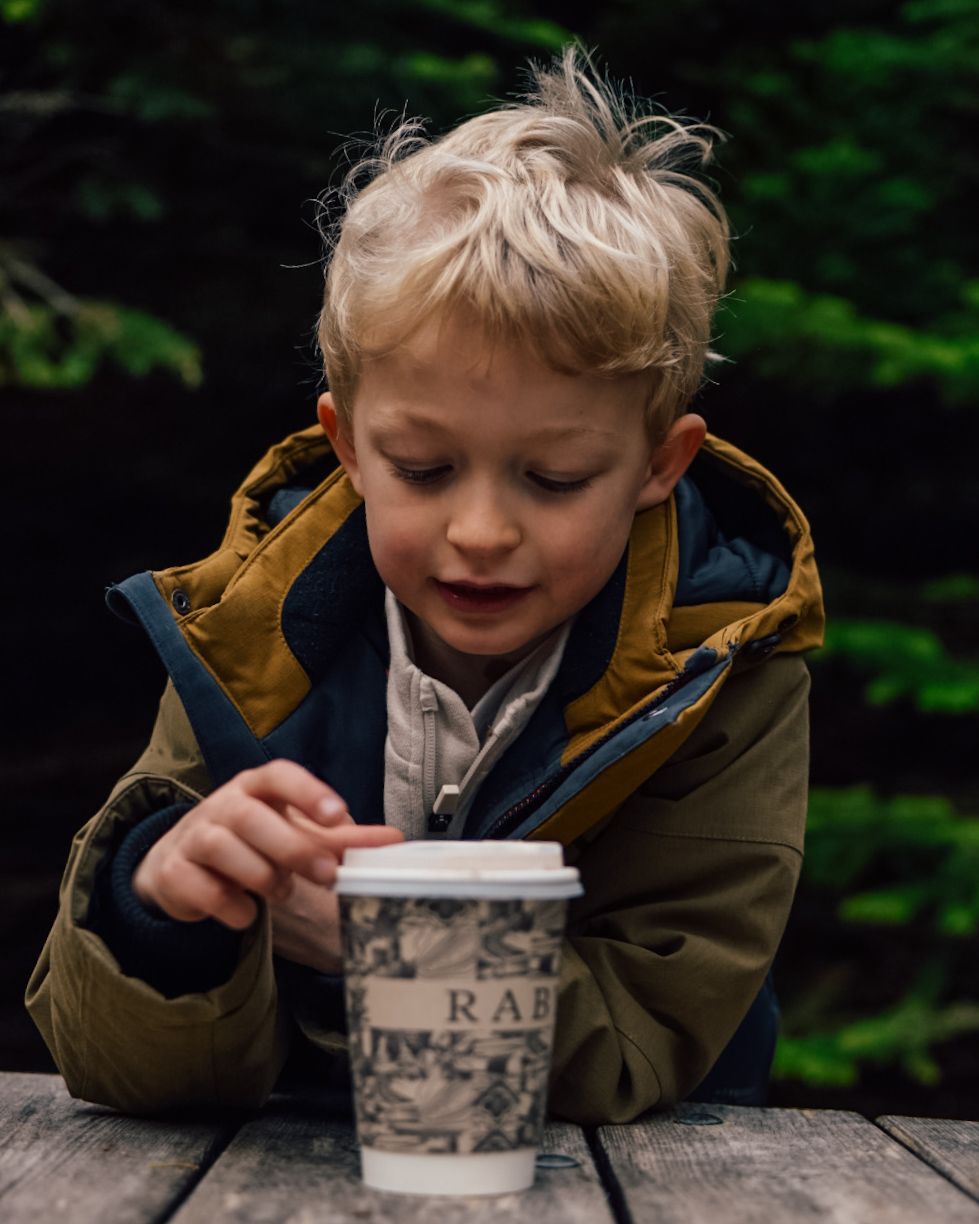 Boy looking at Raby Castle paper cup