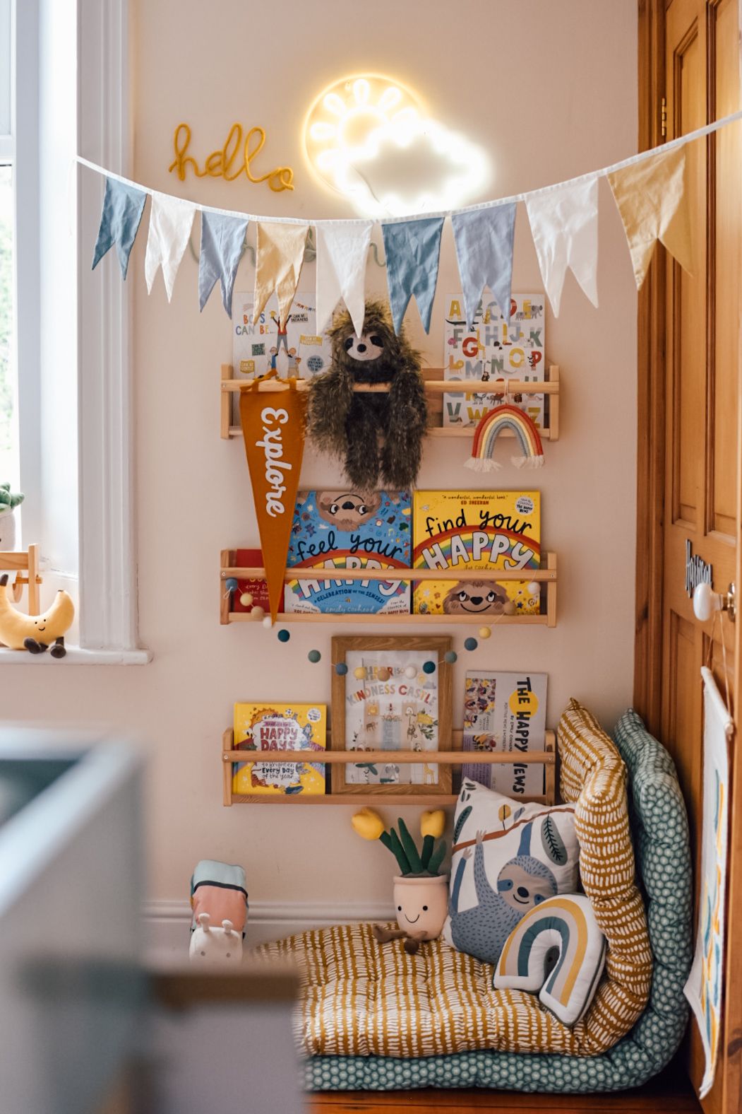 Reading corner with bookcase wall full of books facing forwards and floor cushions to sit on