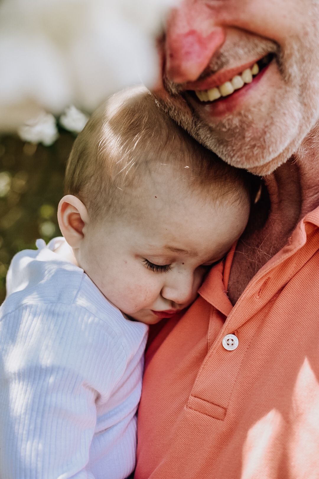 Baby snugged into chest of man with his face partially visible