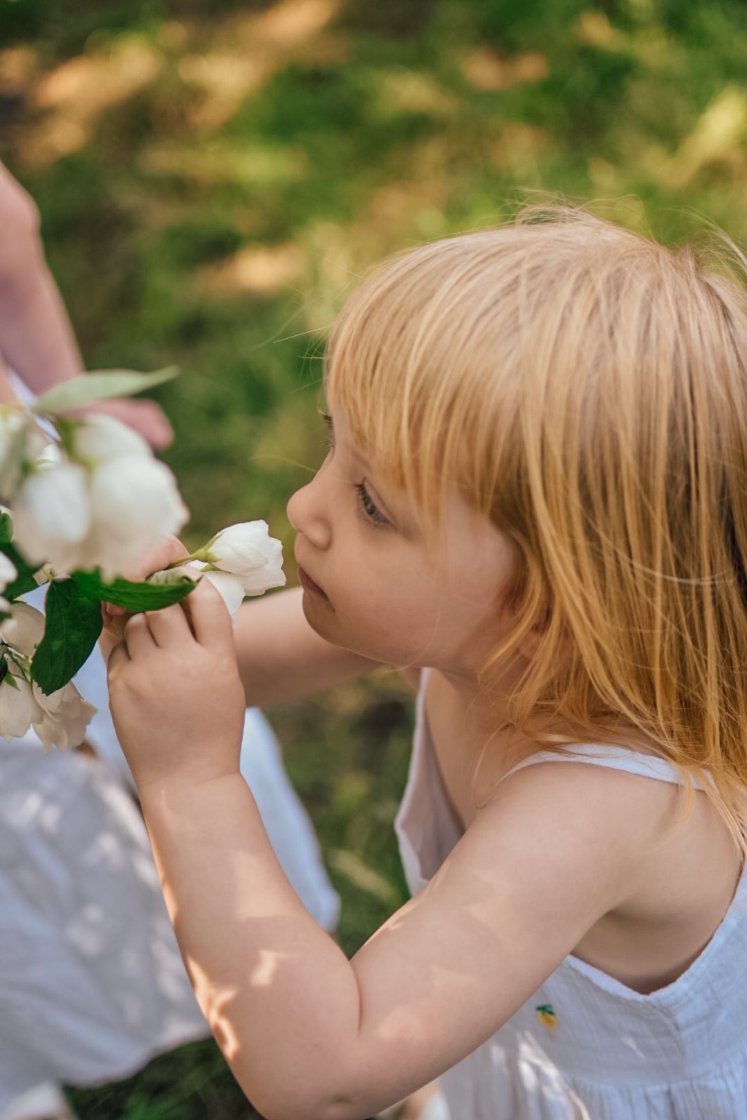 Girl smells blossom flowers in garden