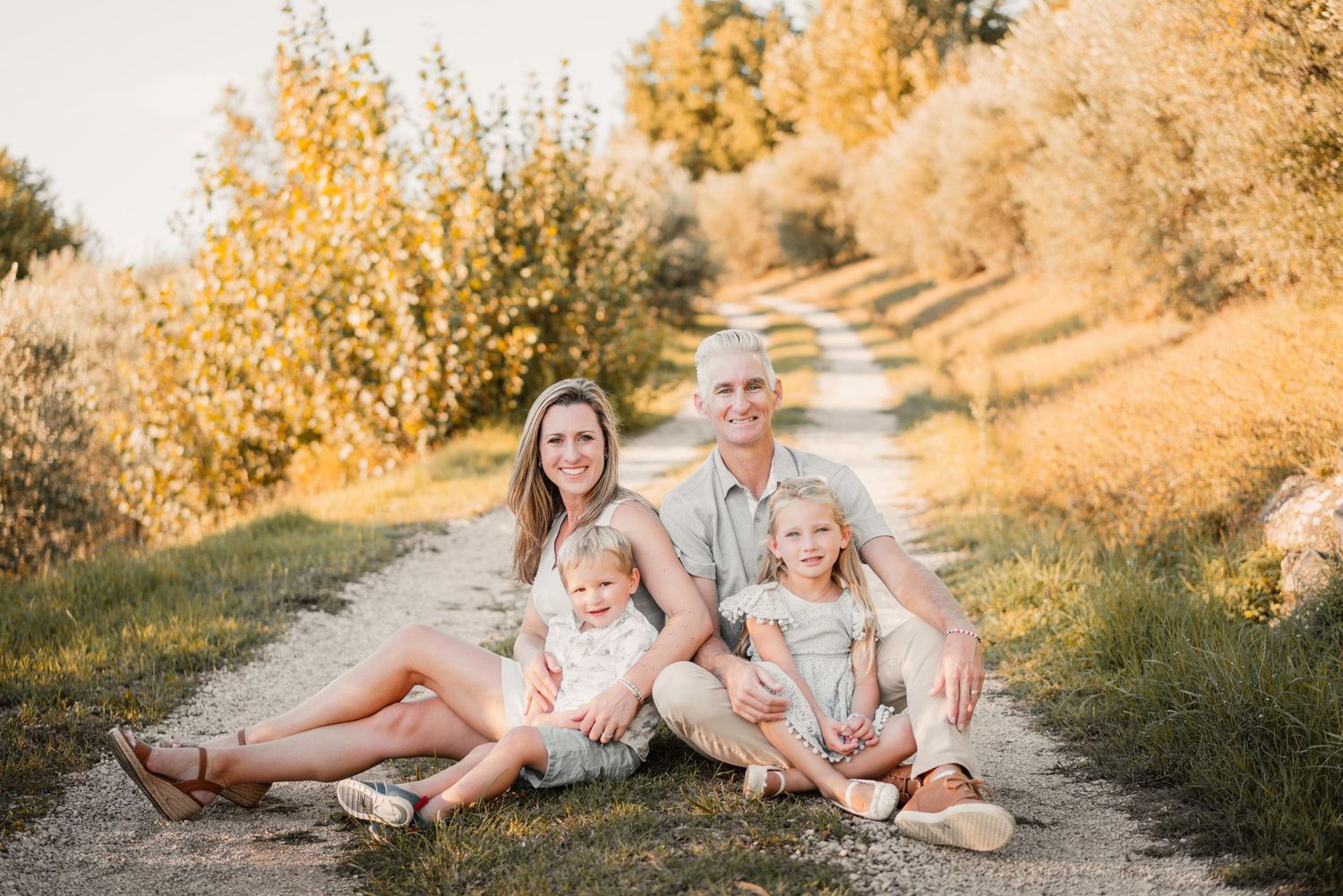 family photography featuring a mother and father with two children in the tuscan wine country