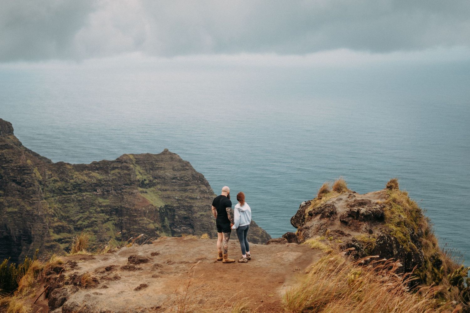 Kaua‘i engagement shoot on the Nā Pali Coast with romantic sunset beach photos, ocean views, and tropical Hawai‘i scenery.