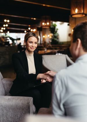 Profesional de servicios Legales conversando con un cliente en un entorno de atención personalizada.