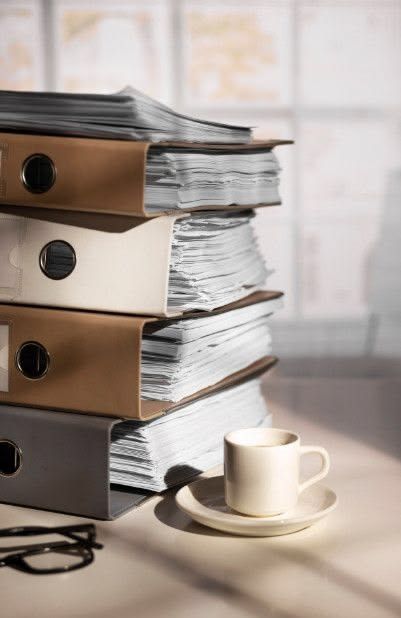 Expedientes y libros de consulta en un escritorio, elementos relacionados con la investigación y el análisis jurídico.