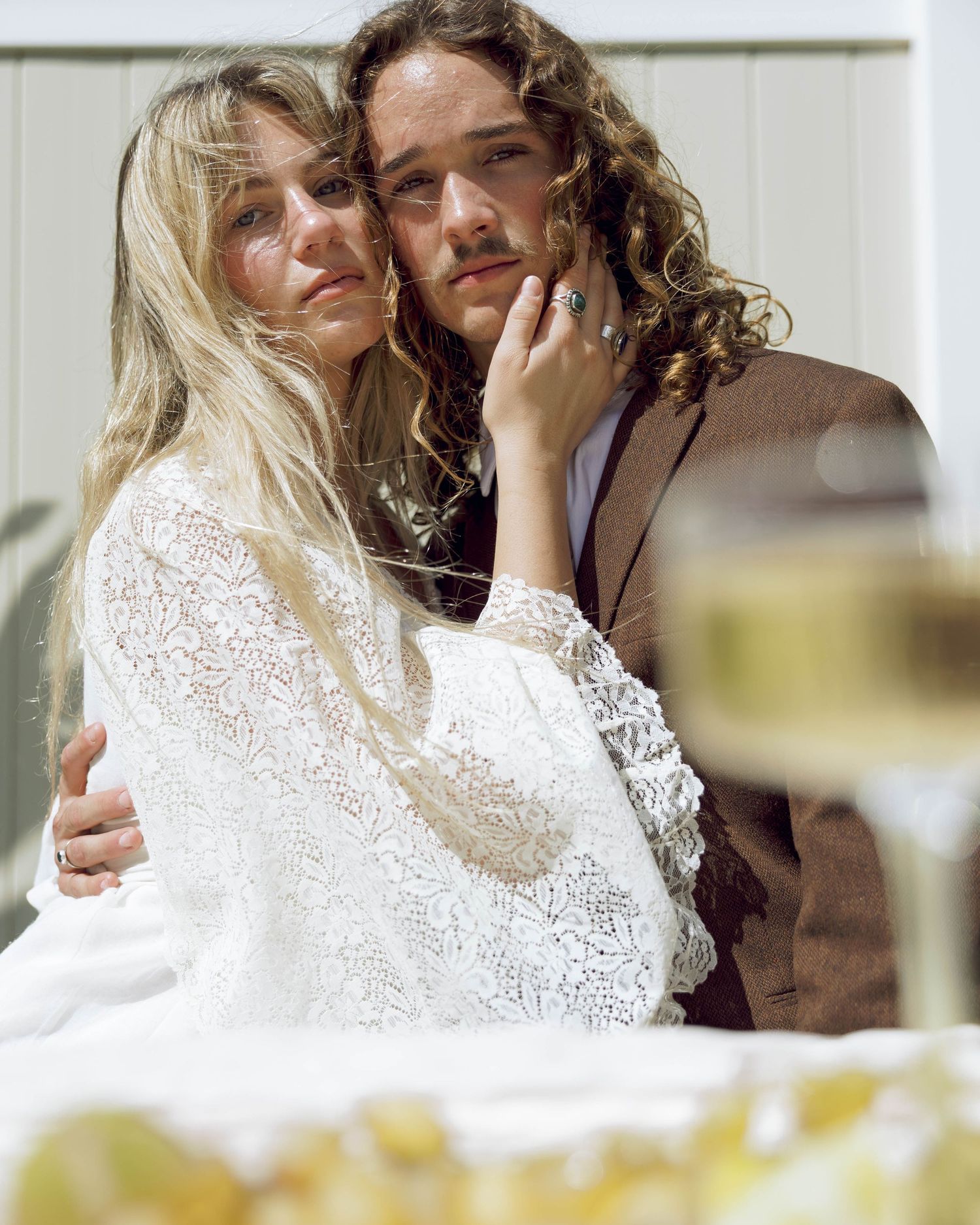 Intimate moment shared at a wedding reception with white lace and brown accents.