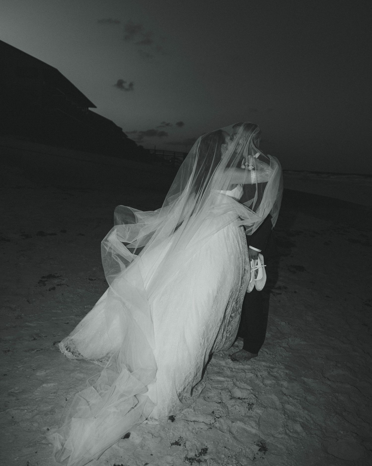 Romantic nighttime beach photo session with flowing wedding dress in the moonlight.
