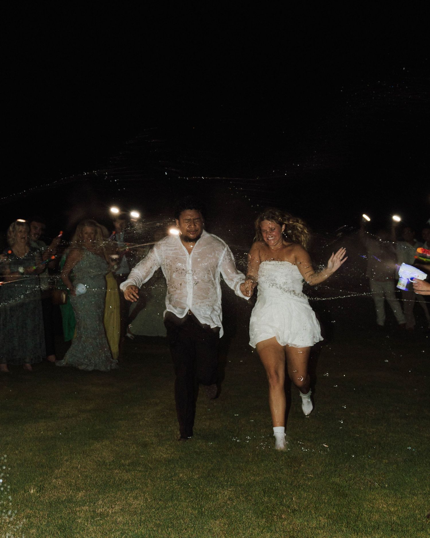 Celebratory nighttime dancing scene at an outdoor wedding reception.