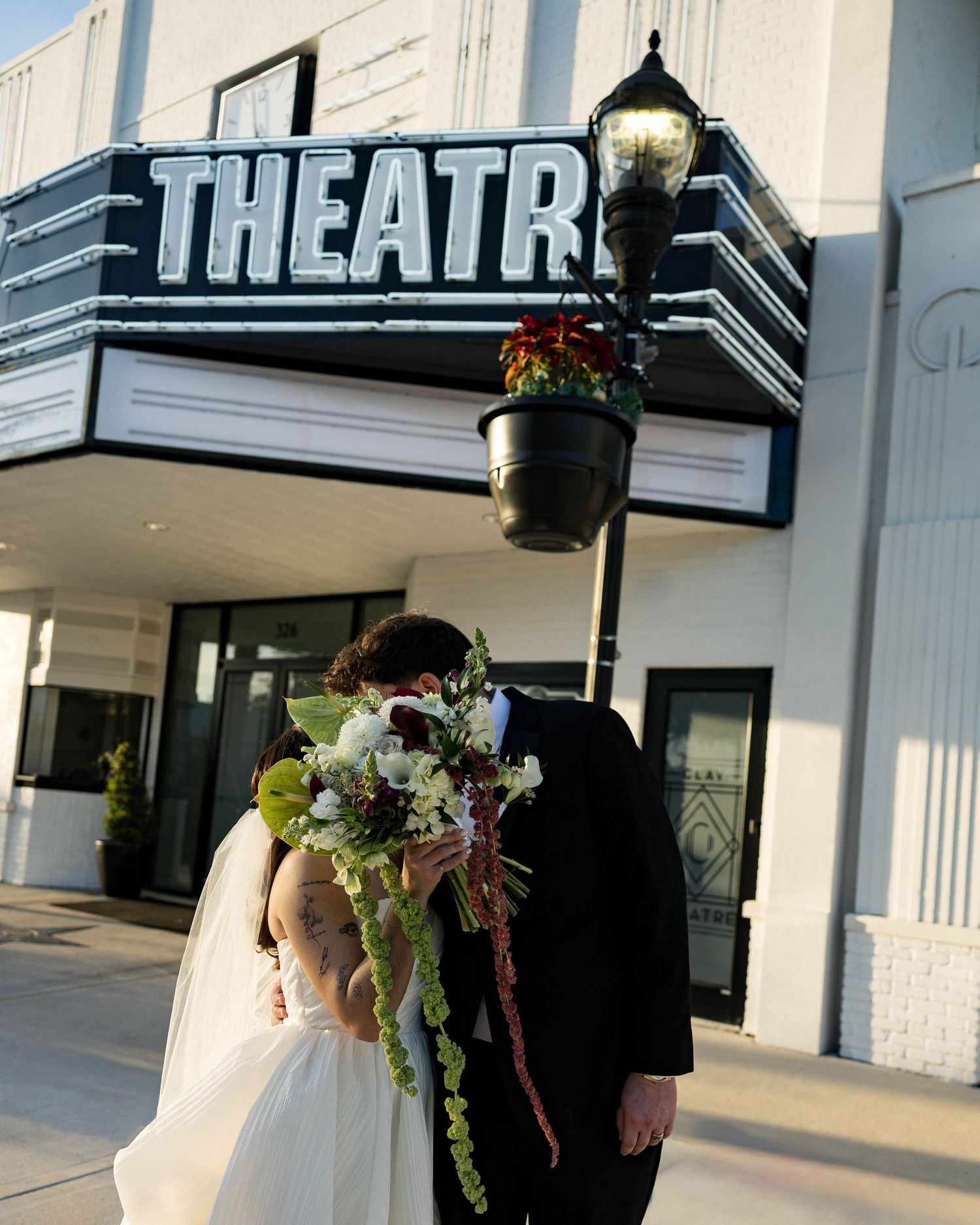 Artistic wedding photo framed by the Clay Theatre's iconic signage and architecture.