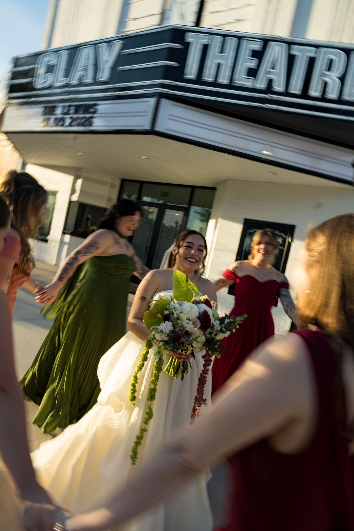 Wedding party gathered outside the Clay Theatre with flowing dresses and bouquets.