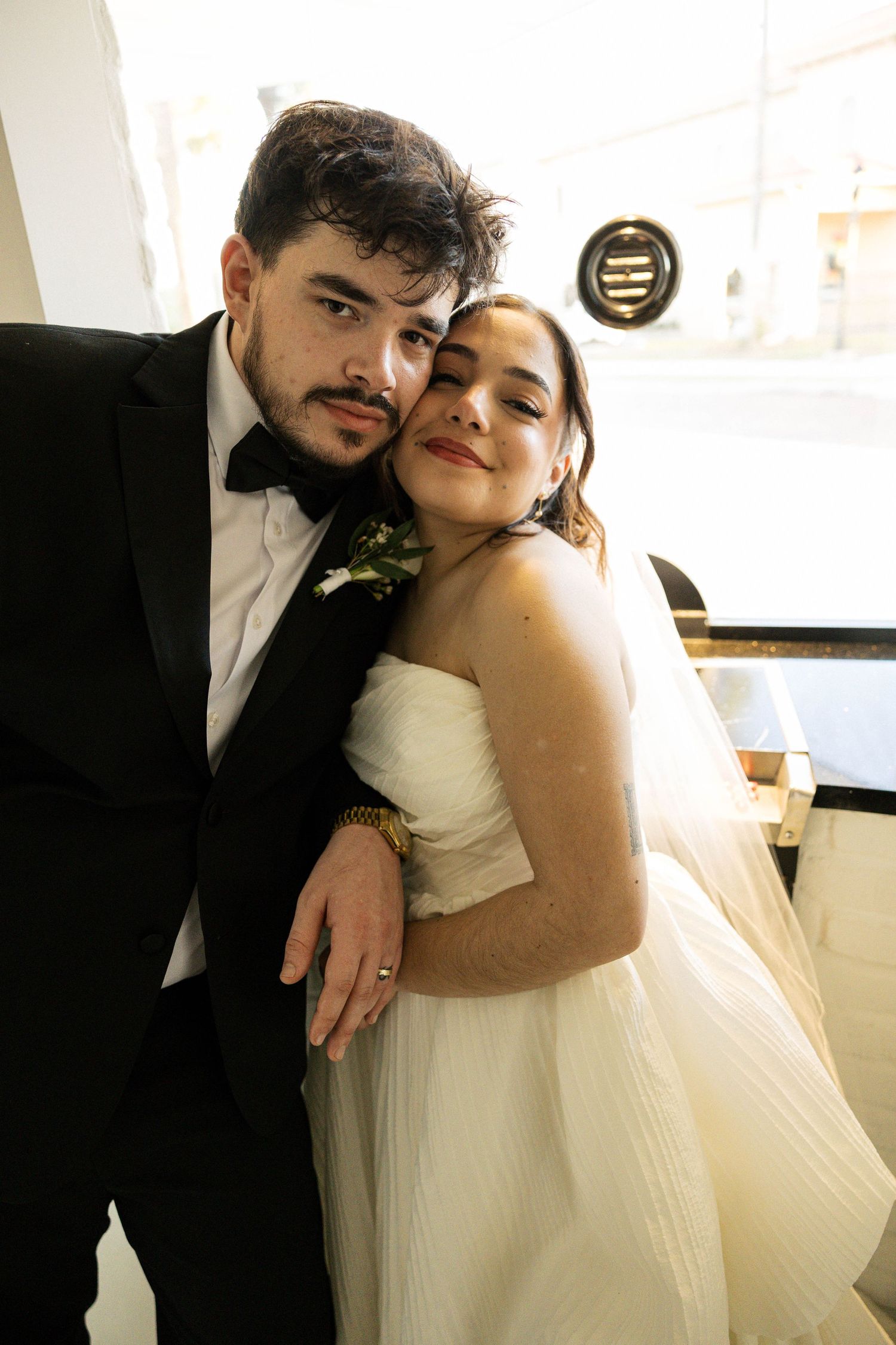 Intimate wedding portraits in warm natural light against white walls.