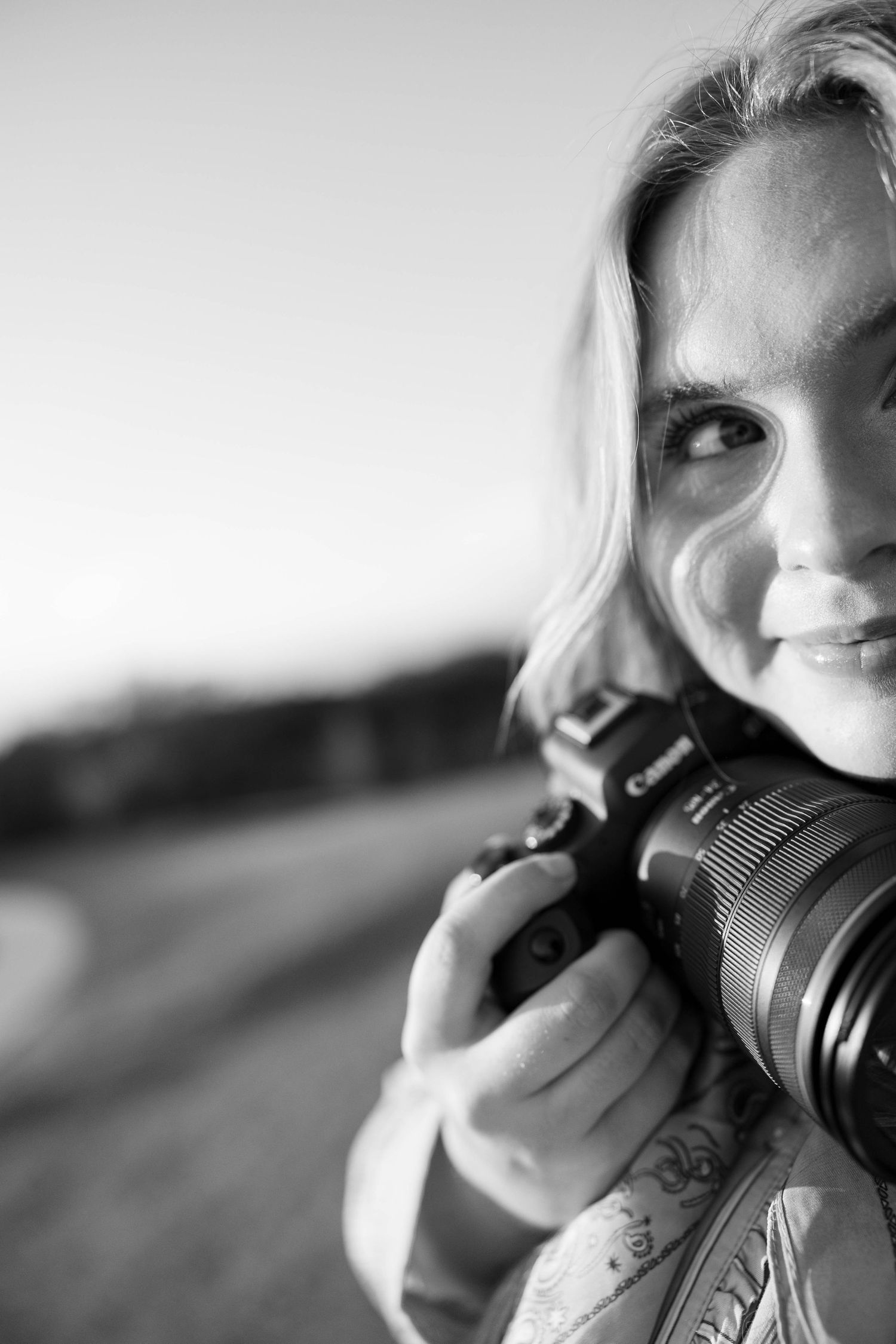 A series of black and white photos showing a photographer looking through a camera lens.