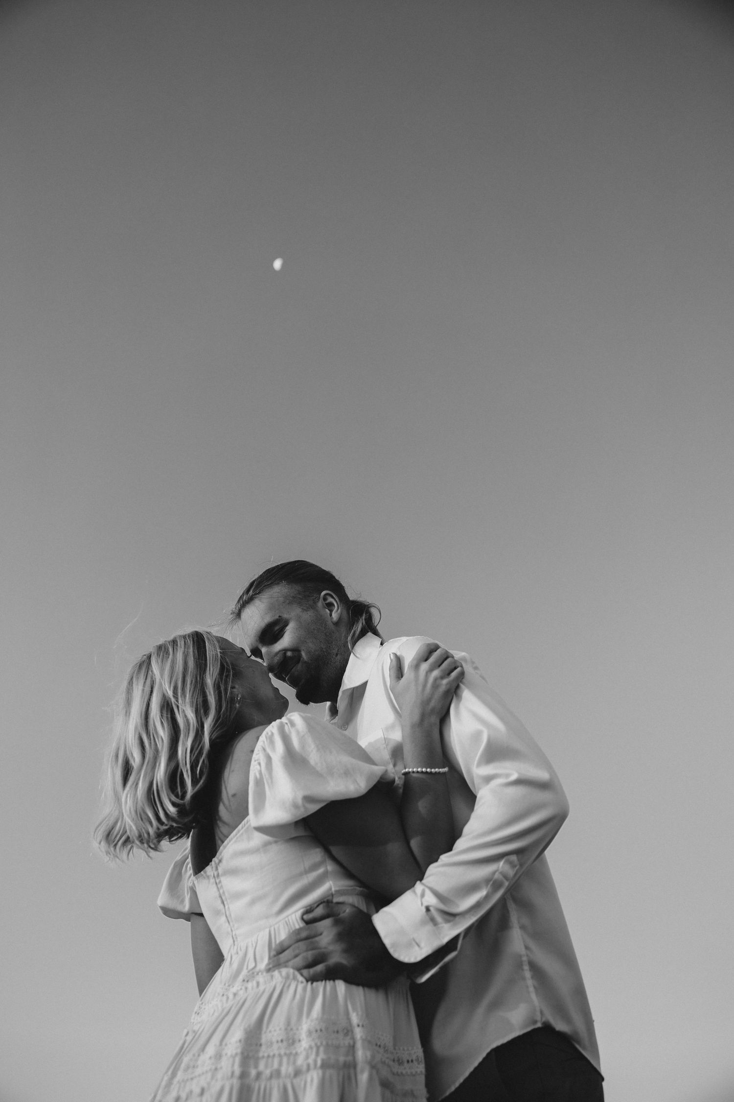 Minimalist black and white photography capturing intimate moments against plain background.