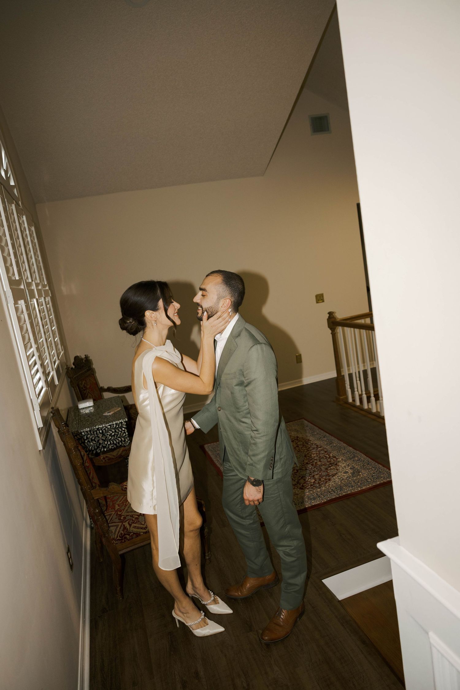 A couple shares an intimate moment in a dimly lit indoor setting.