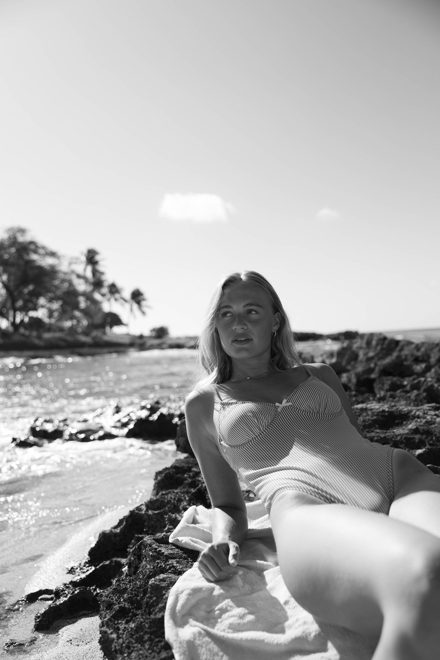 Black and white beach portraits showing relaxed poses on volcanic coastline.